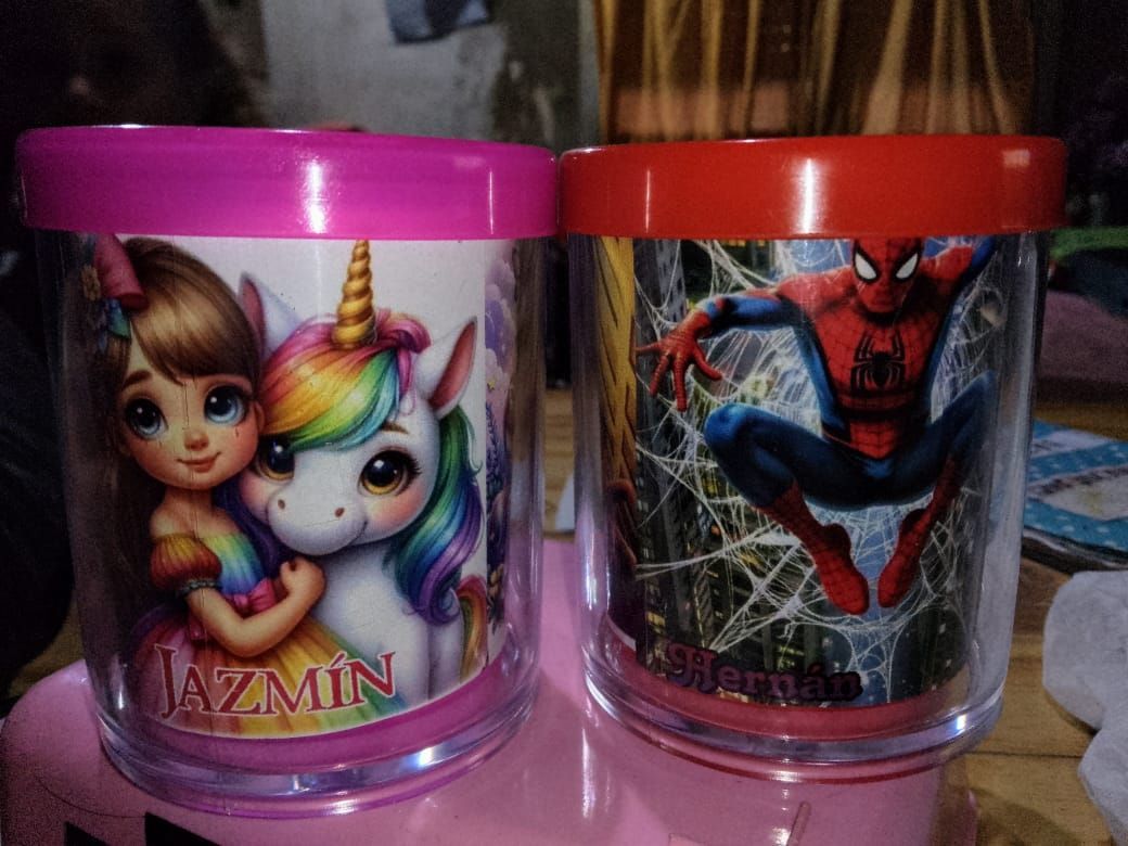 Dos vasos de plástico: diseño de niña y unicornio, y diseño de Spiderman. Tapas rosa y roja.