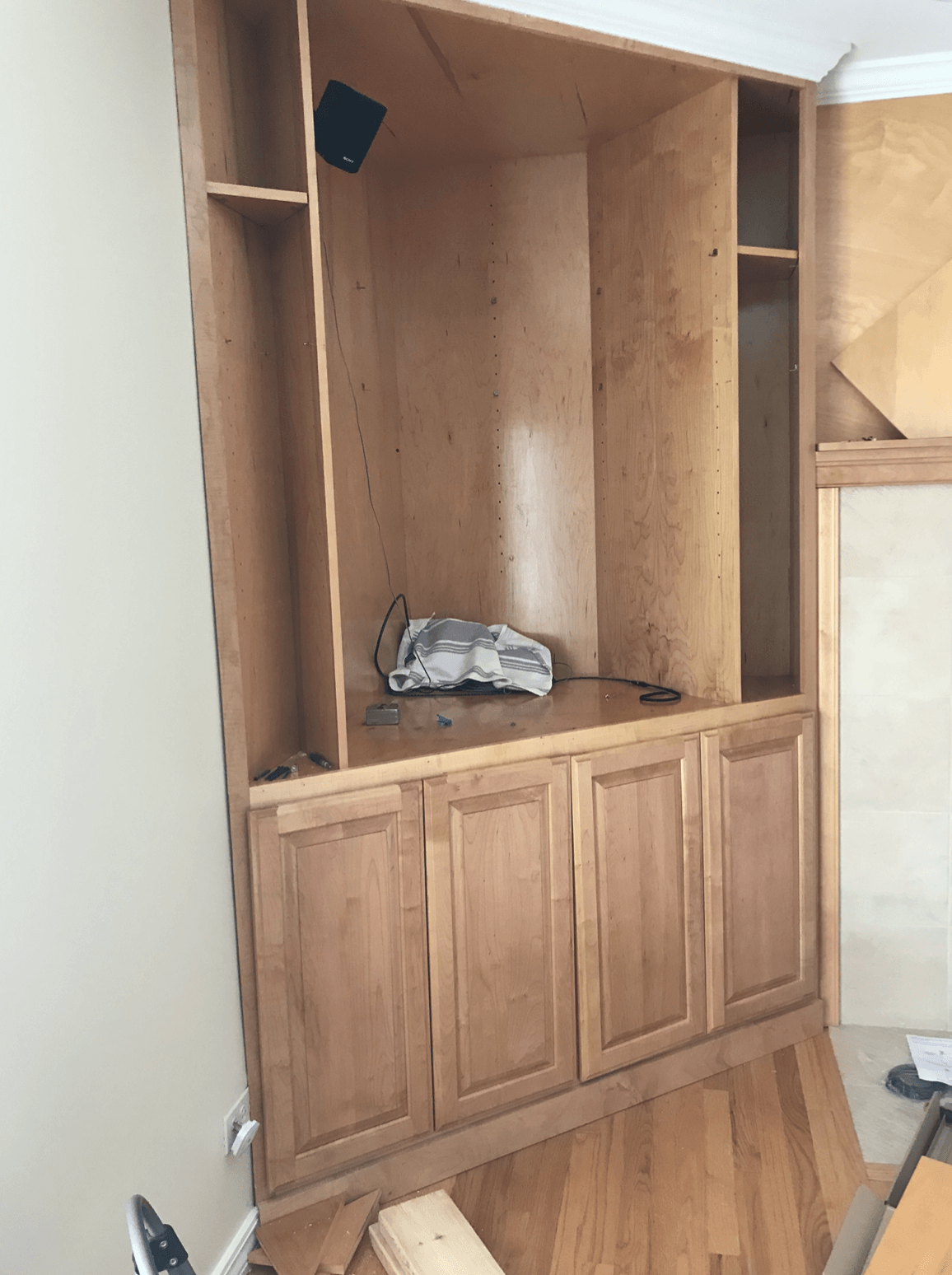 A wooden entertainment center is being built in a living room.