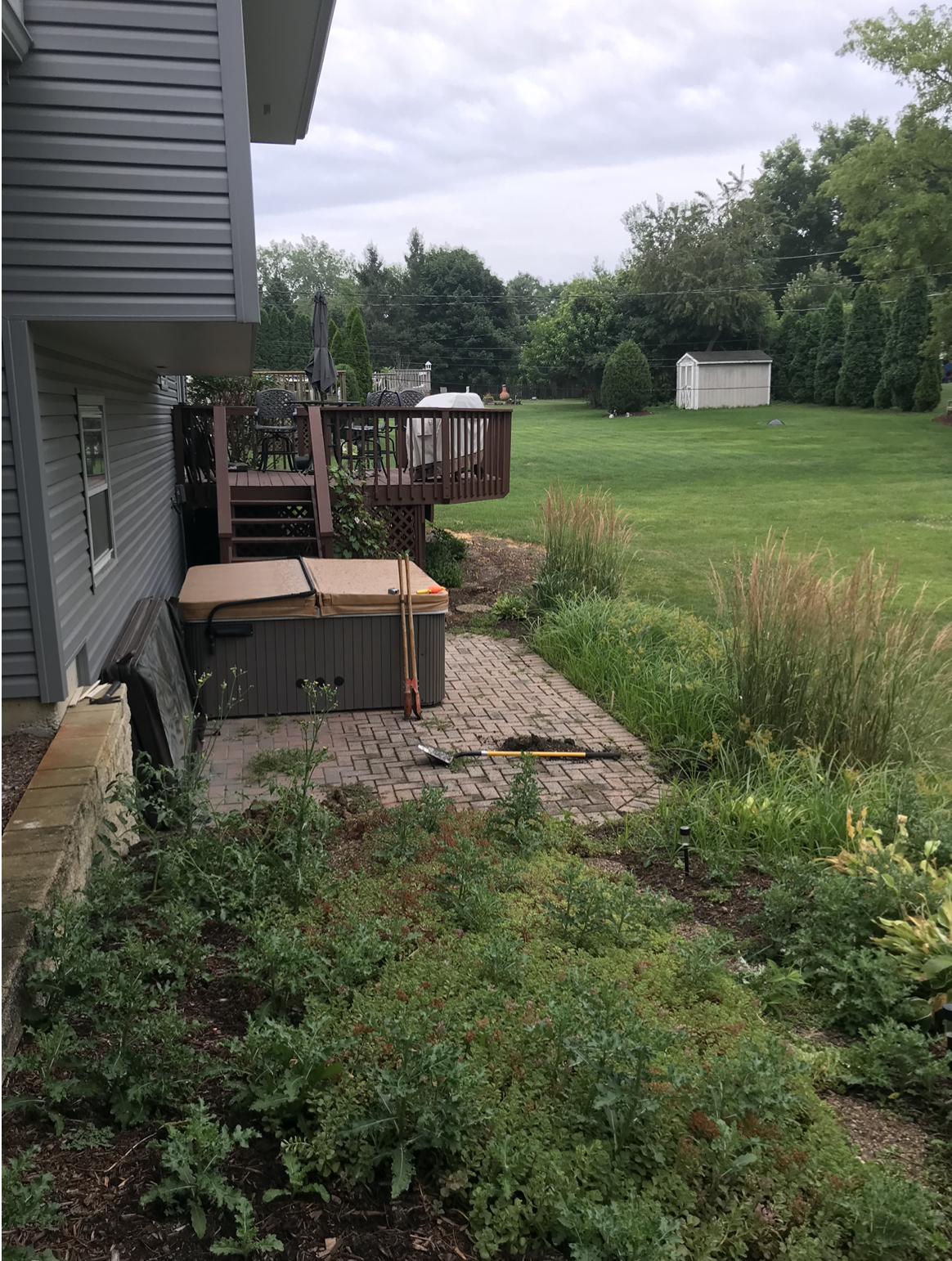 A hot tub is sitting on a patio next to a house.