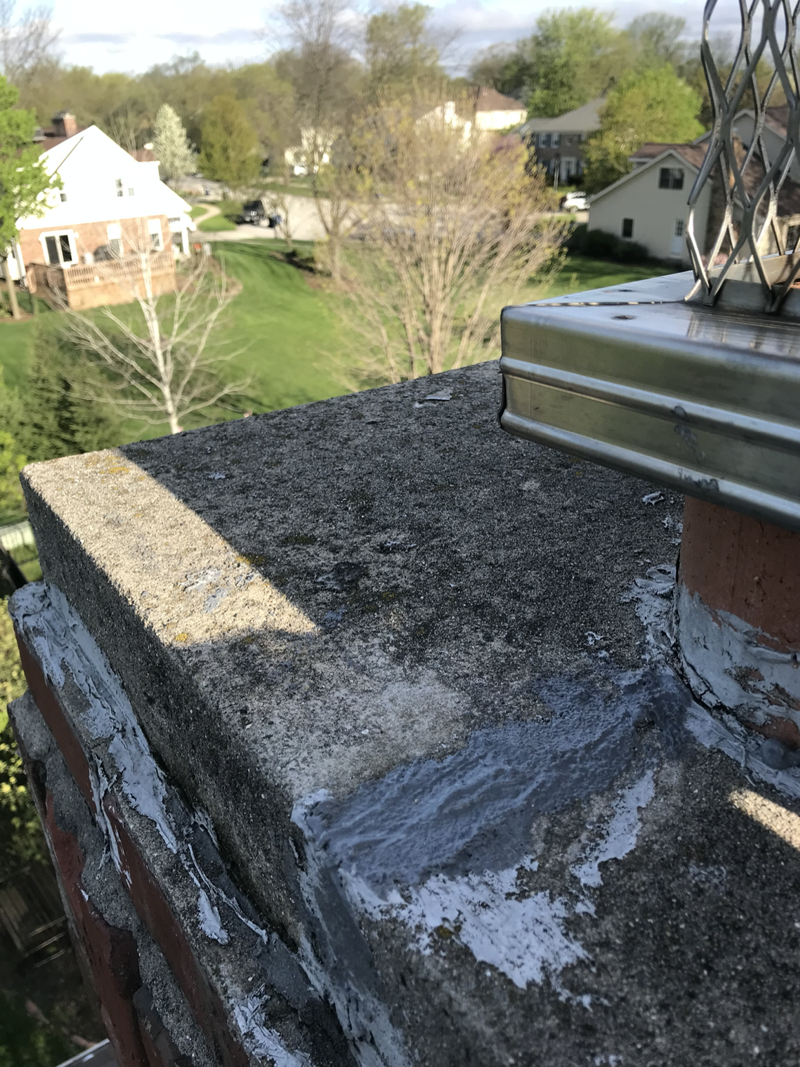 A brick chimney sitting on top of a concrete roof.