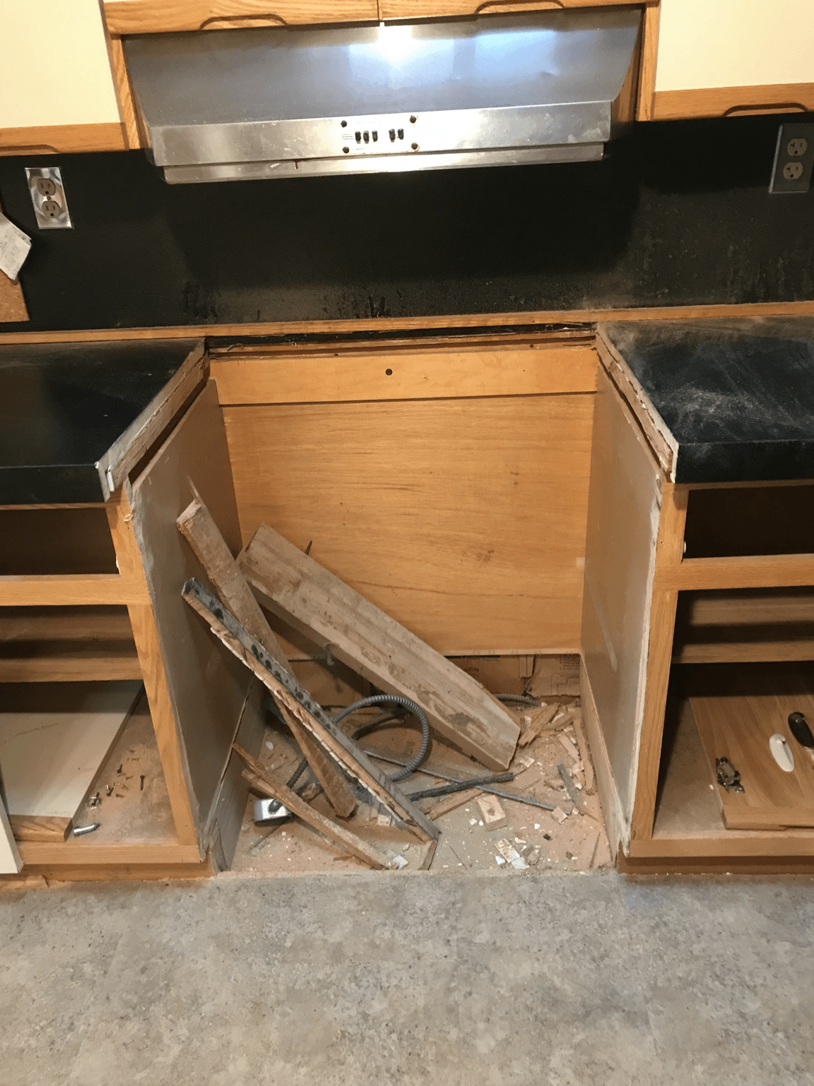 A kitchen with wooden cabinets and a stainless steel hood