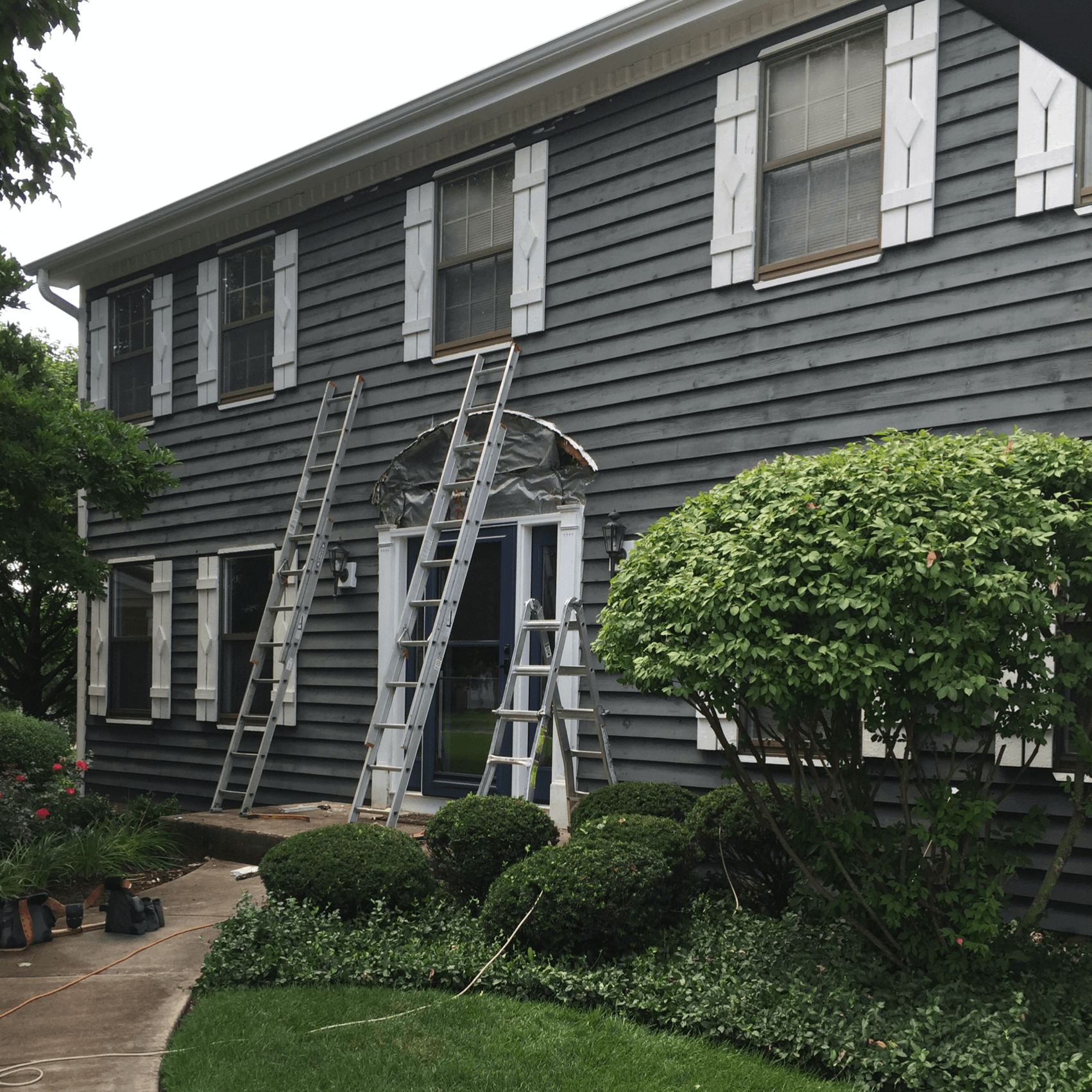 A house is being painted with a ladder in front of it