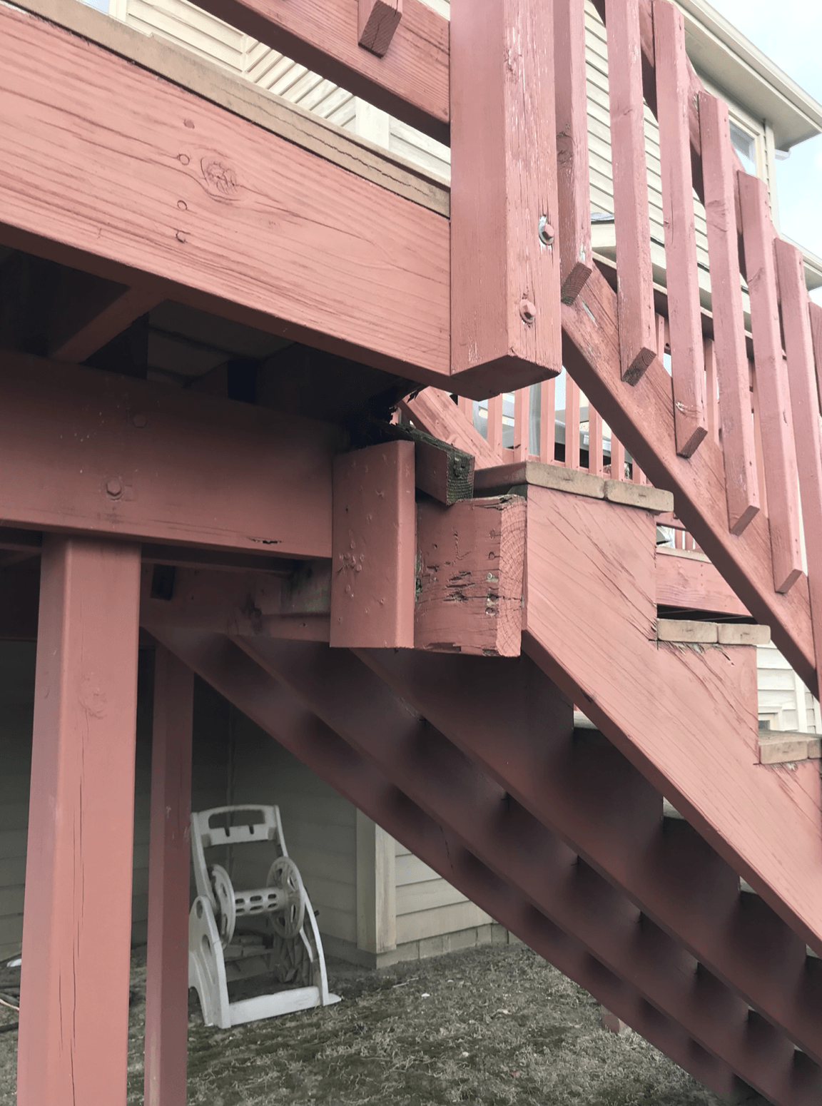 A pink wooden deck with stairs leading up to it.