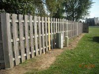 A wooden fence is sitting in the middle of a grassy field.