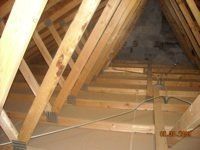 A picture of the inside of an attic with wooden beams.