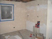 A room with a window and a ladder in it is being painted.