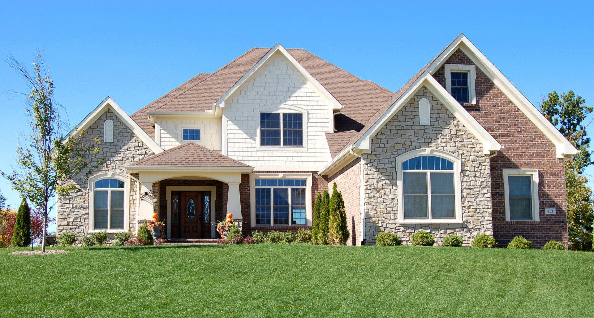 A large house with a lush green lawn in front of it
