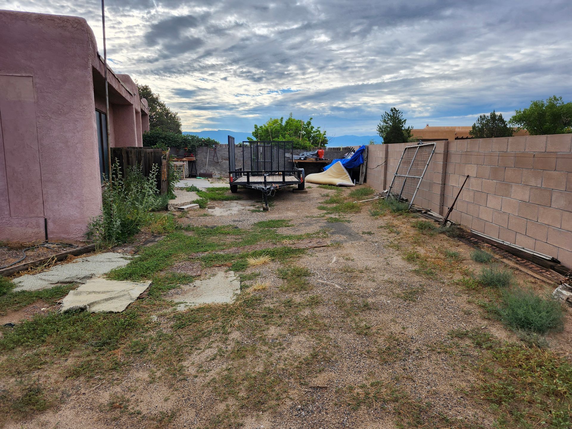 A trailer is parked in the backyard of a house.