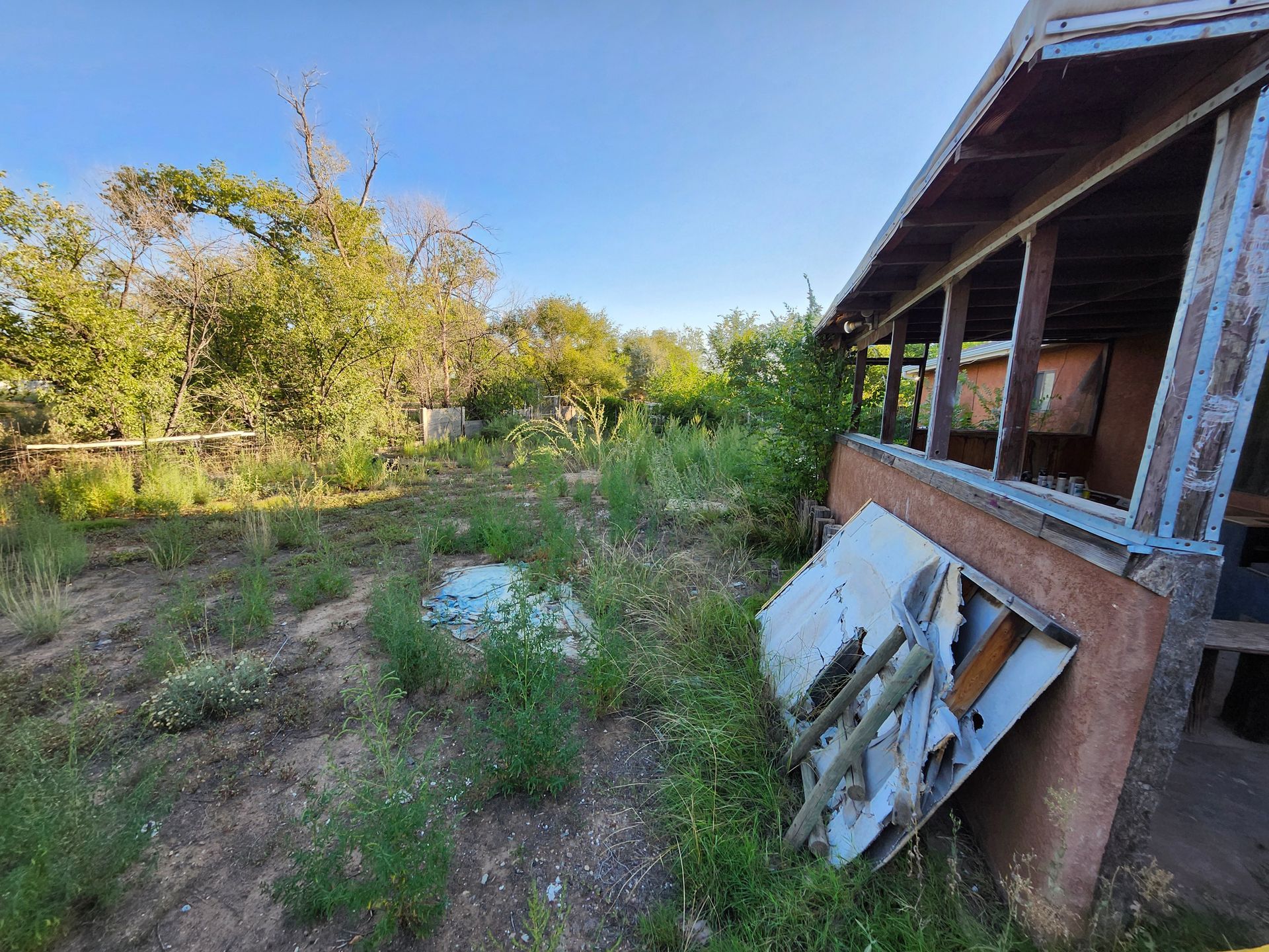 A house is sitting in the middle of a lush green field.