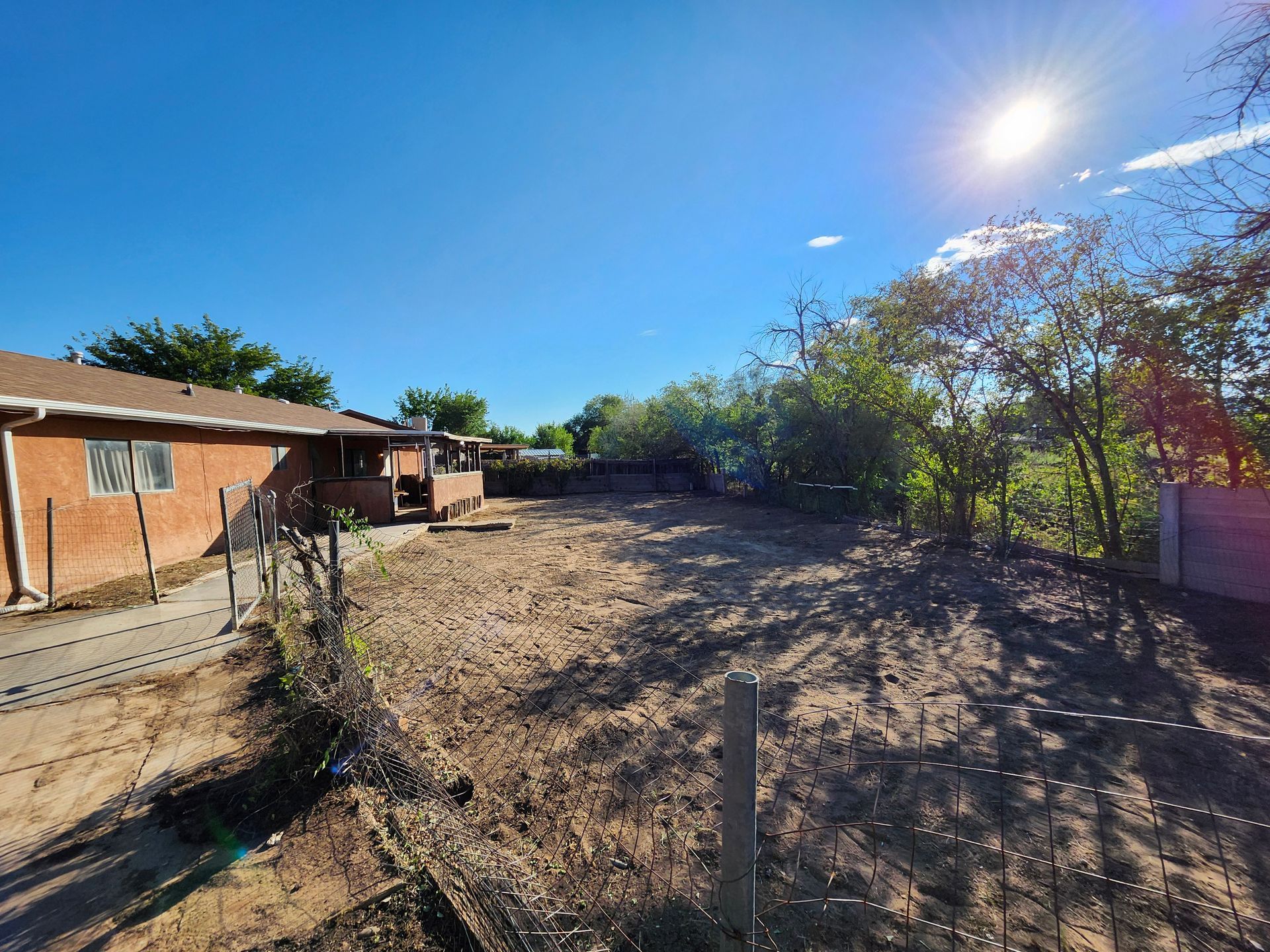 A fenced in yard with a house in the background.
