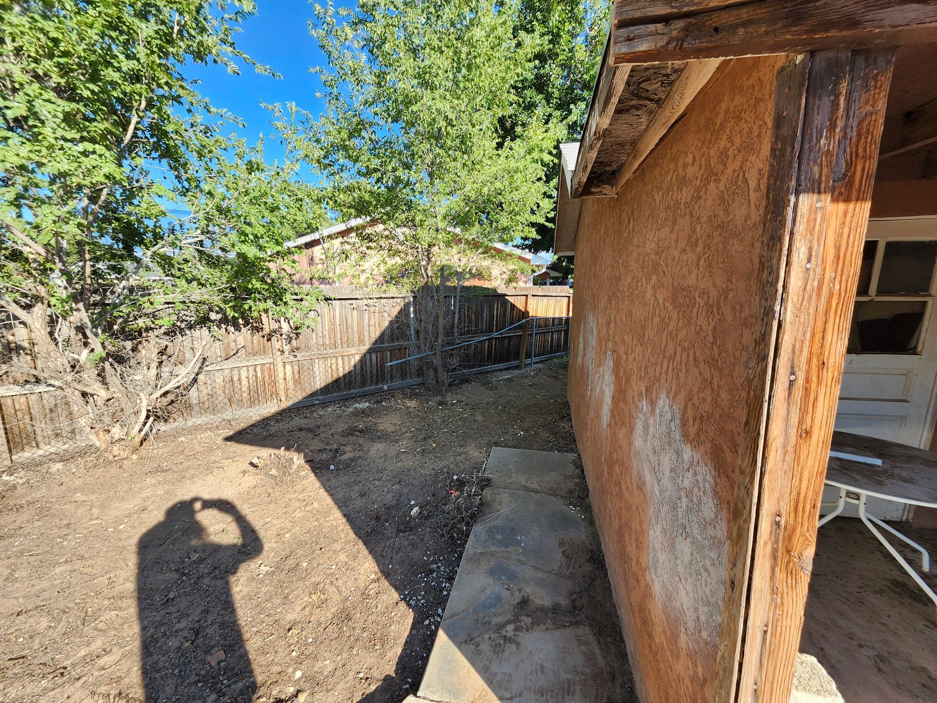 A shadow of a person is cast on the side of a building.