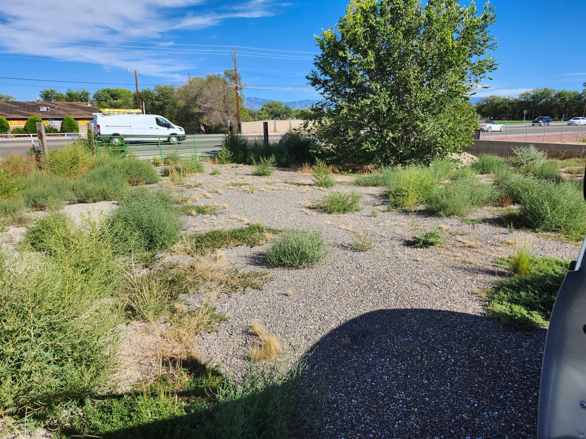A white van is parked in the middle of a dirt field.