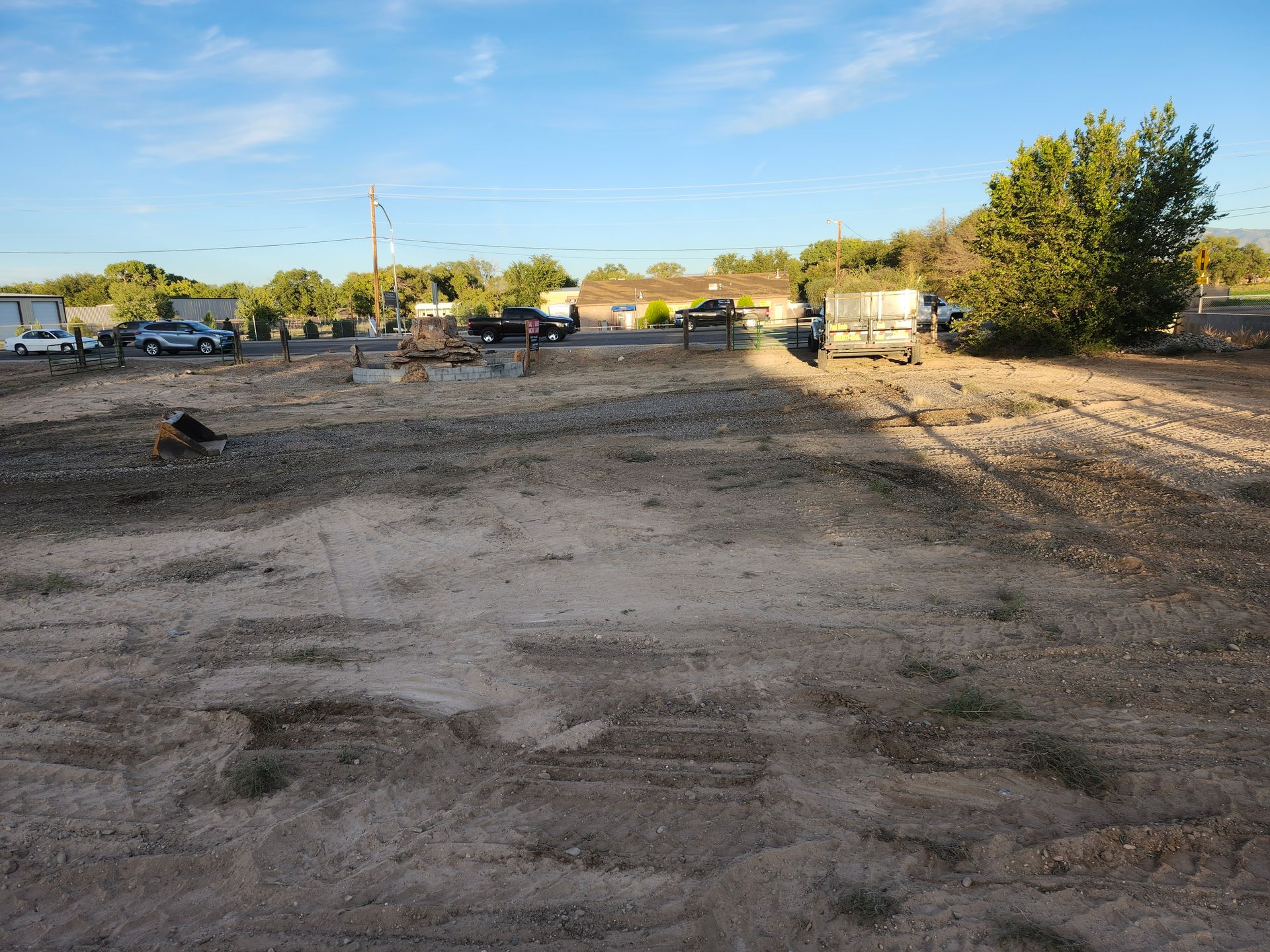 A large dirt field with a lot of trees in the background