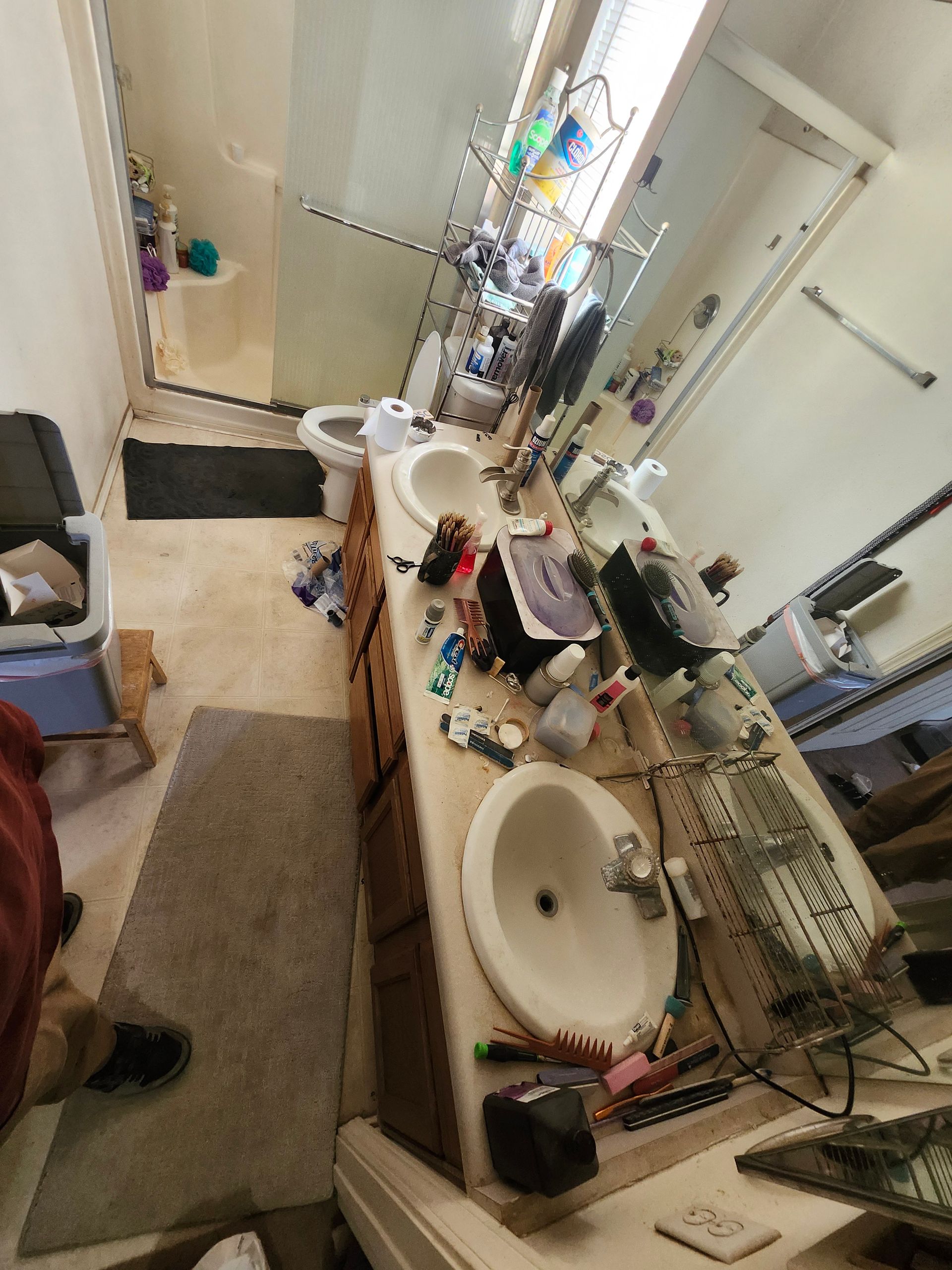 A bathroom with two sinks , a toilet and a mirror.