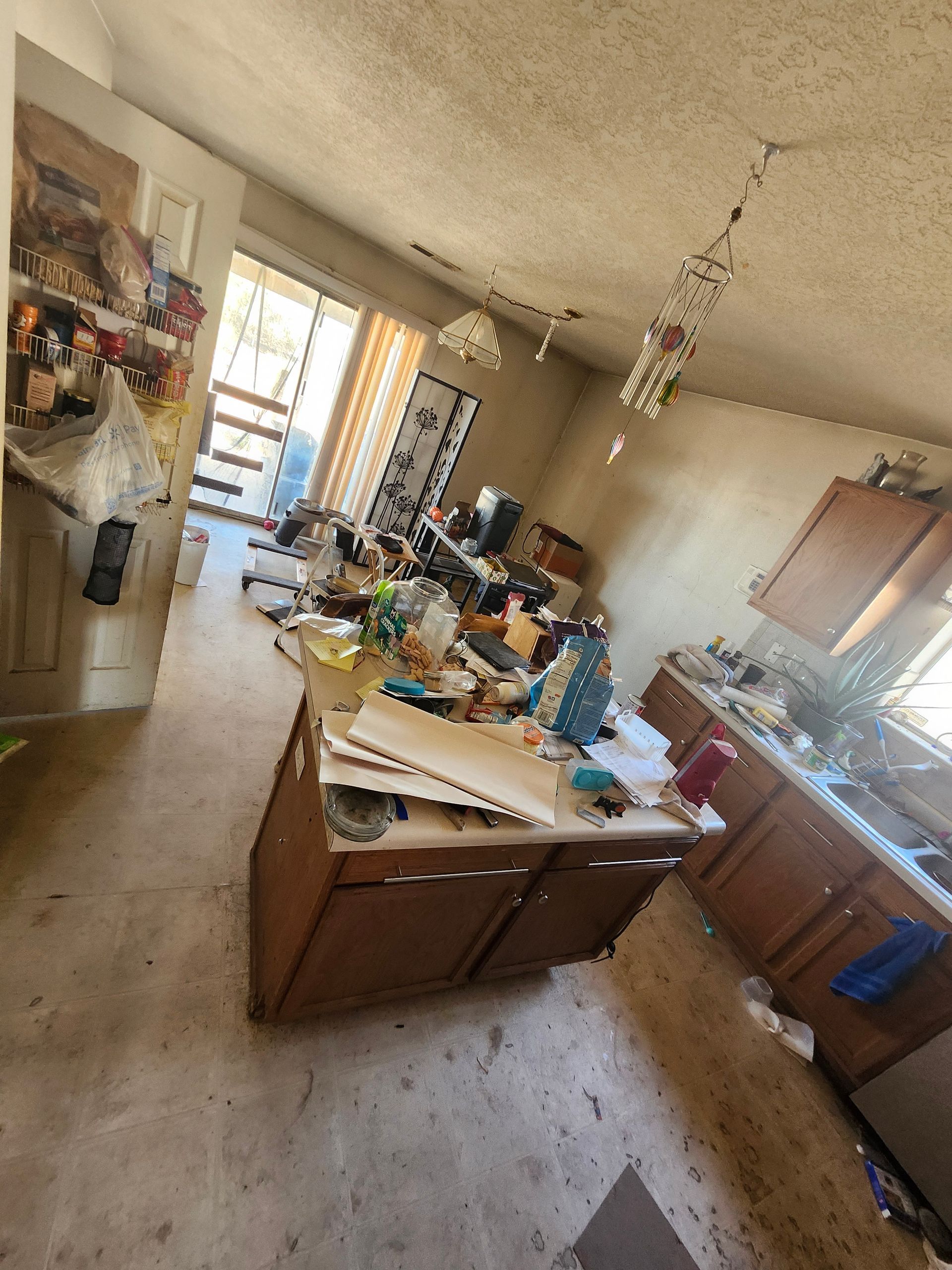 A messy kitchen with a large island in the middle of the room.