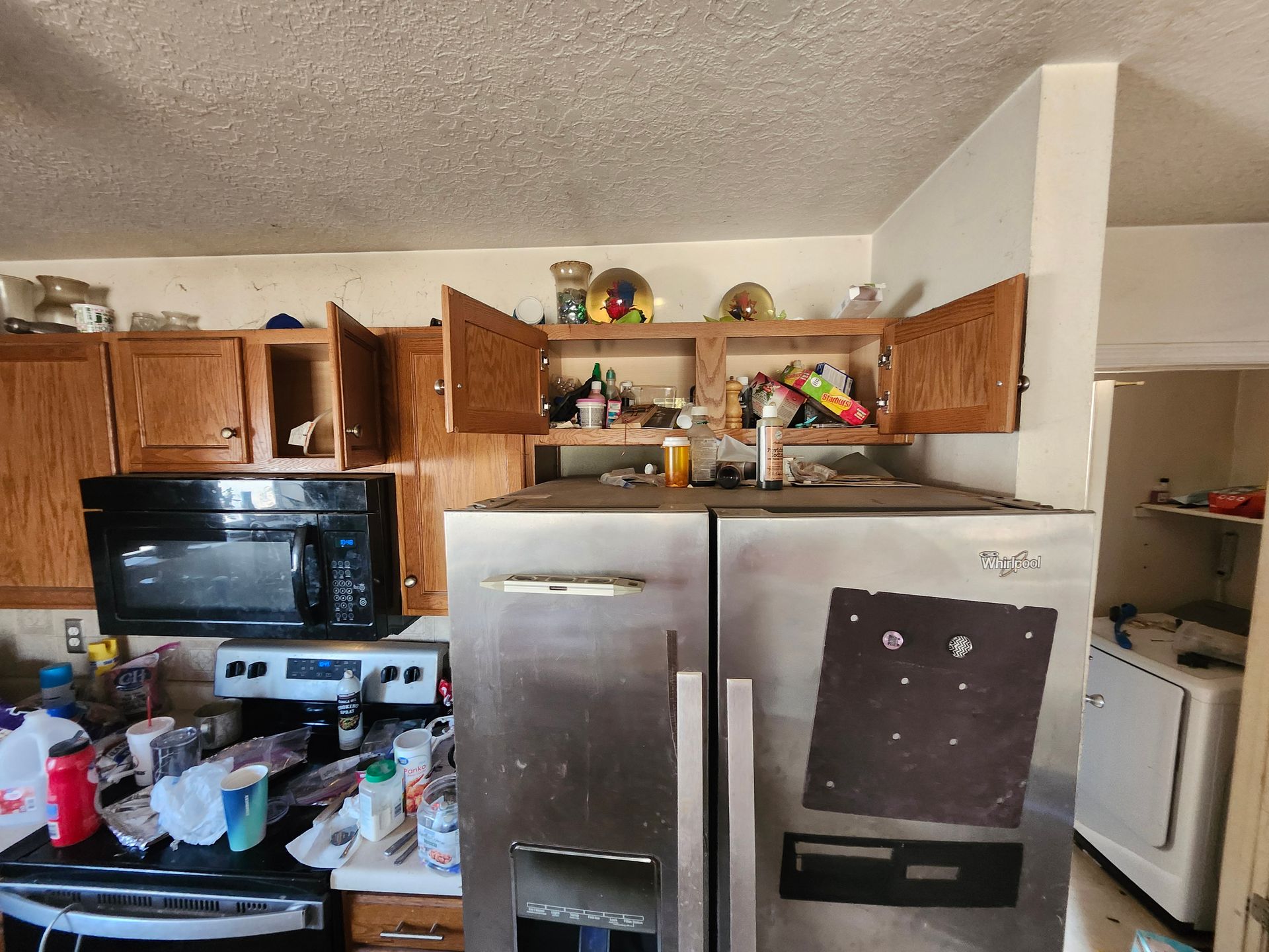 A kitchen with a stainless steel refrigerator and a microwave