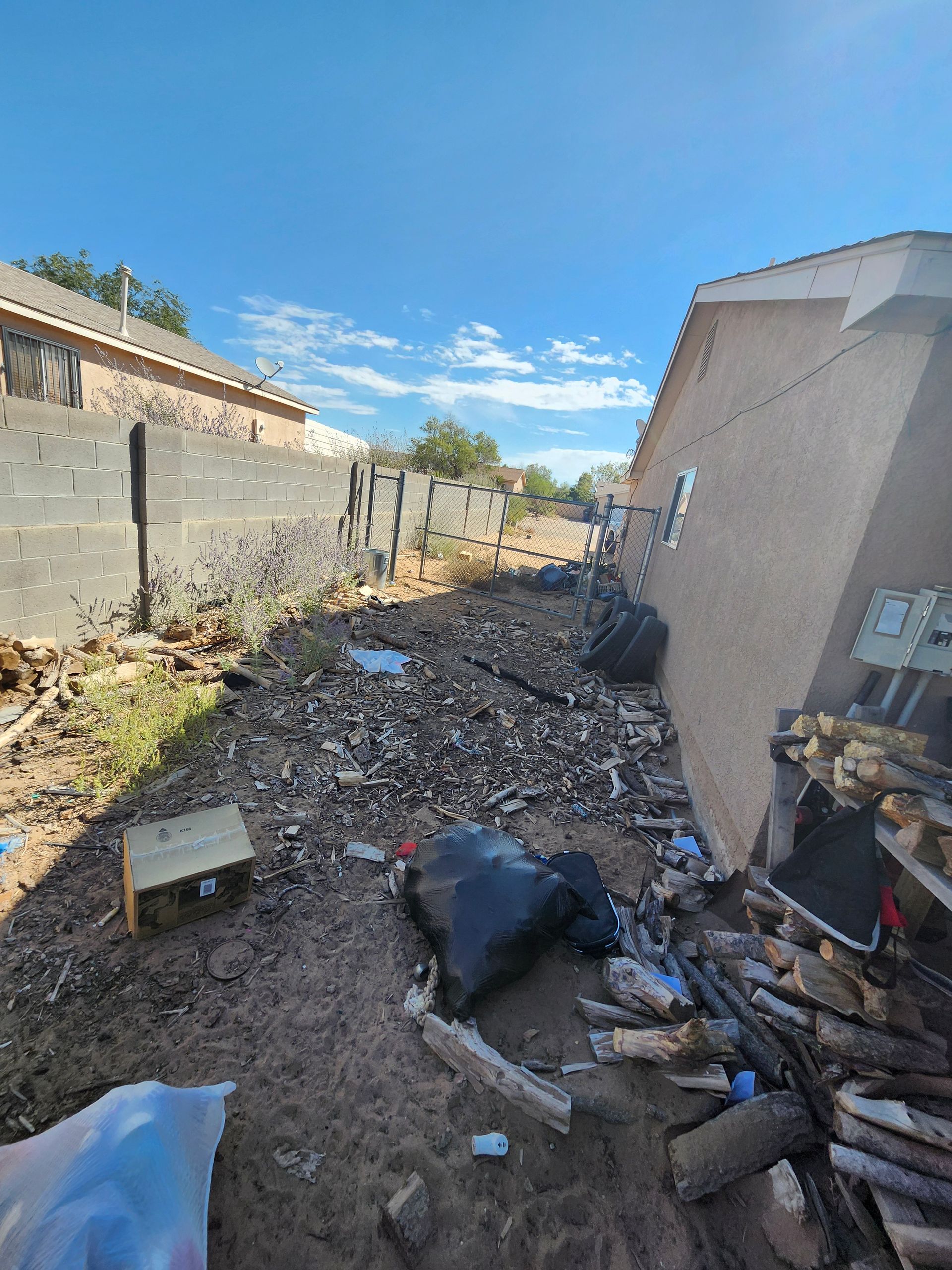 There is a lot of trash in the backyard of a house.