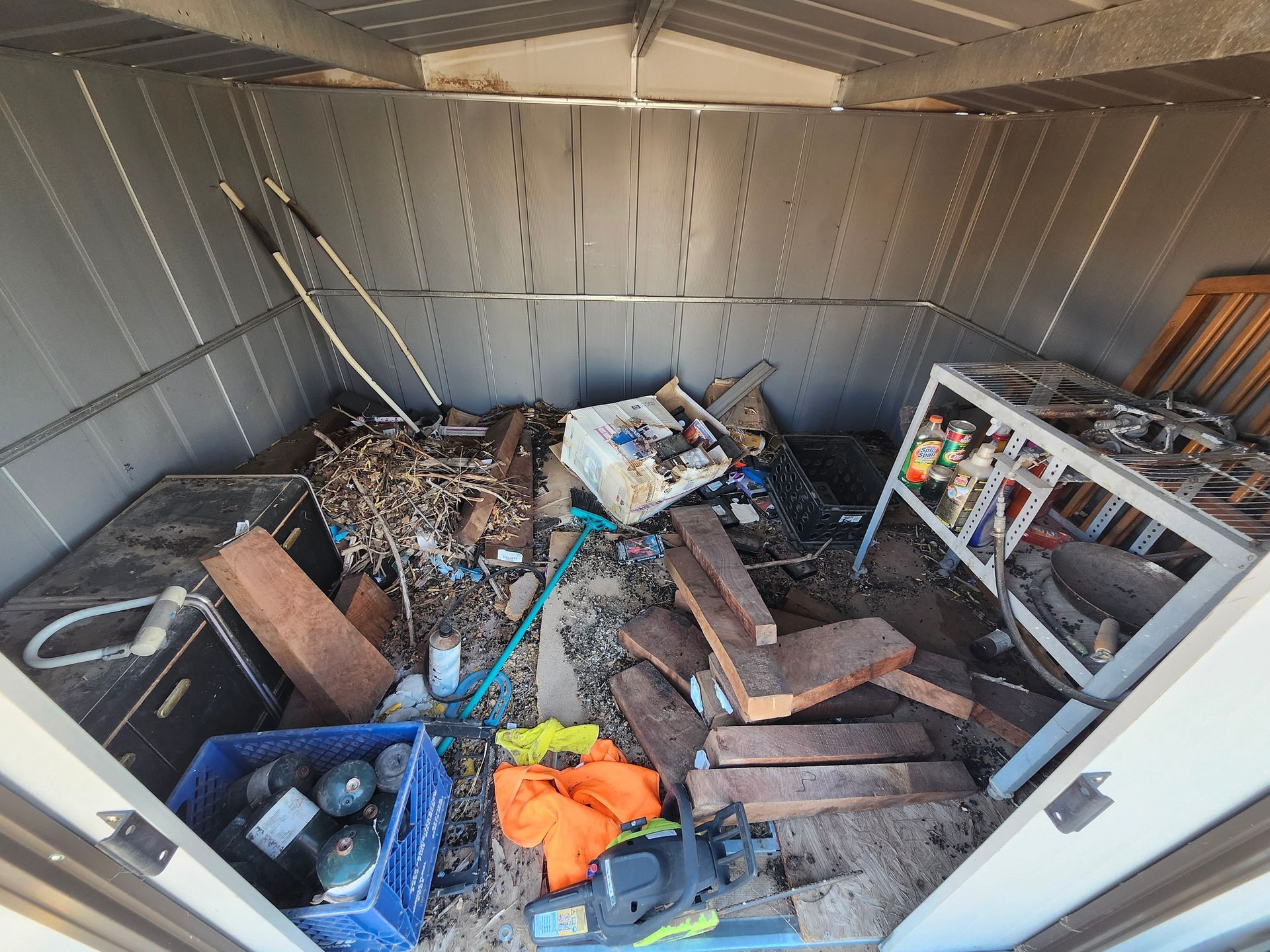 A shed filled with lots of junk and tools.
