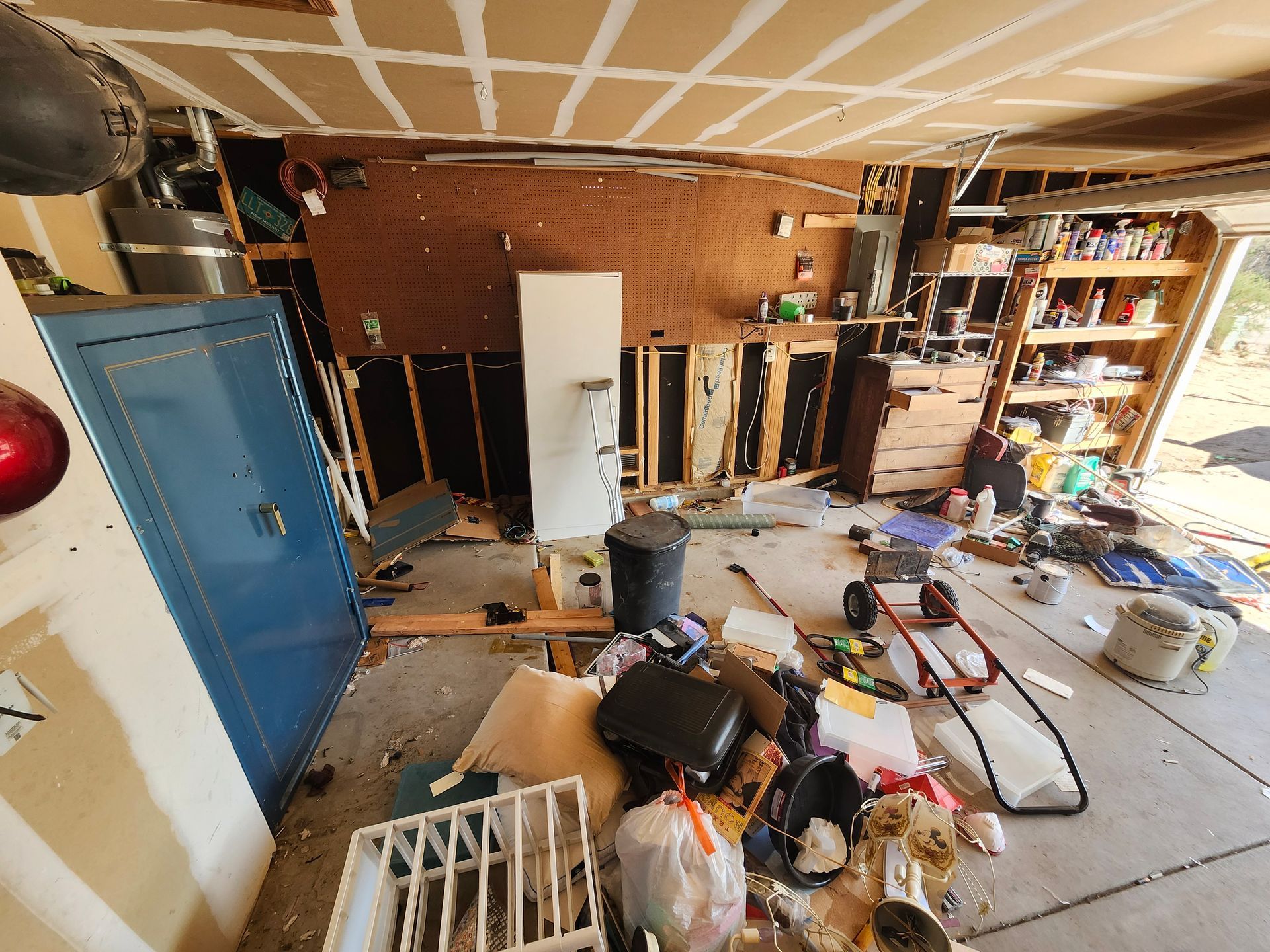 A messy garage with a lot of junk on the floor