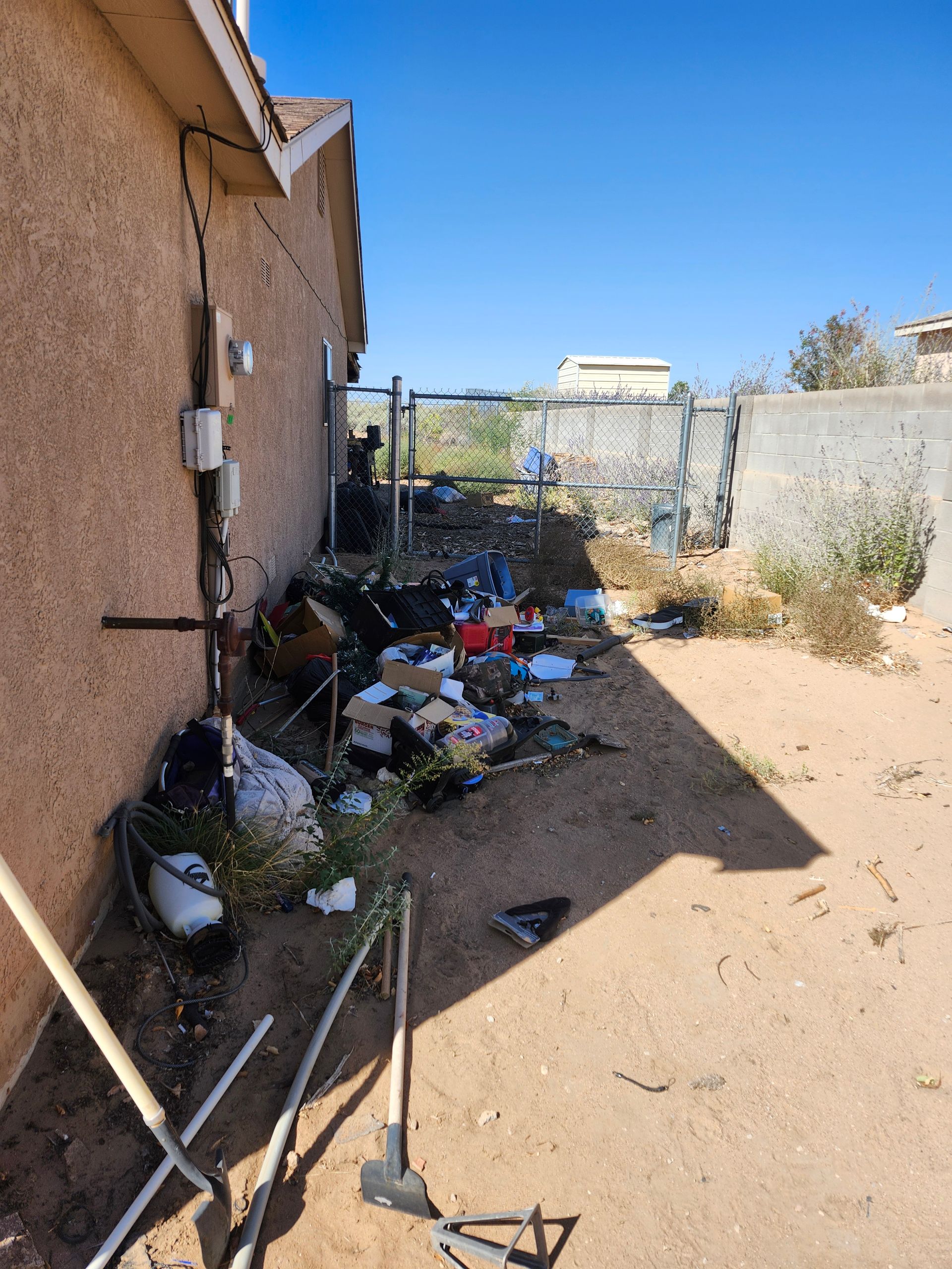 A house with a lot of trash on the ground in front of it.