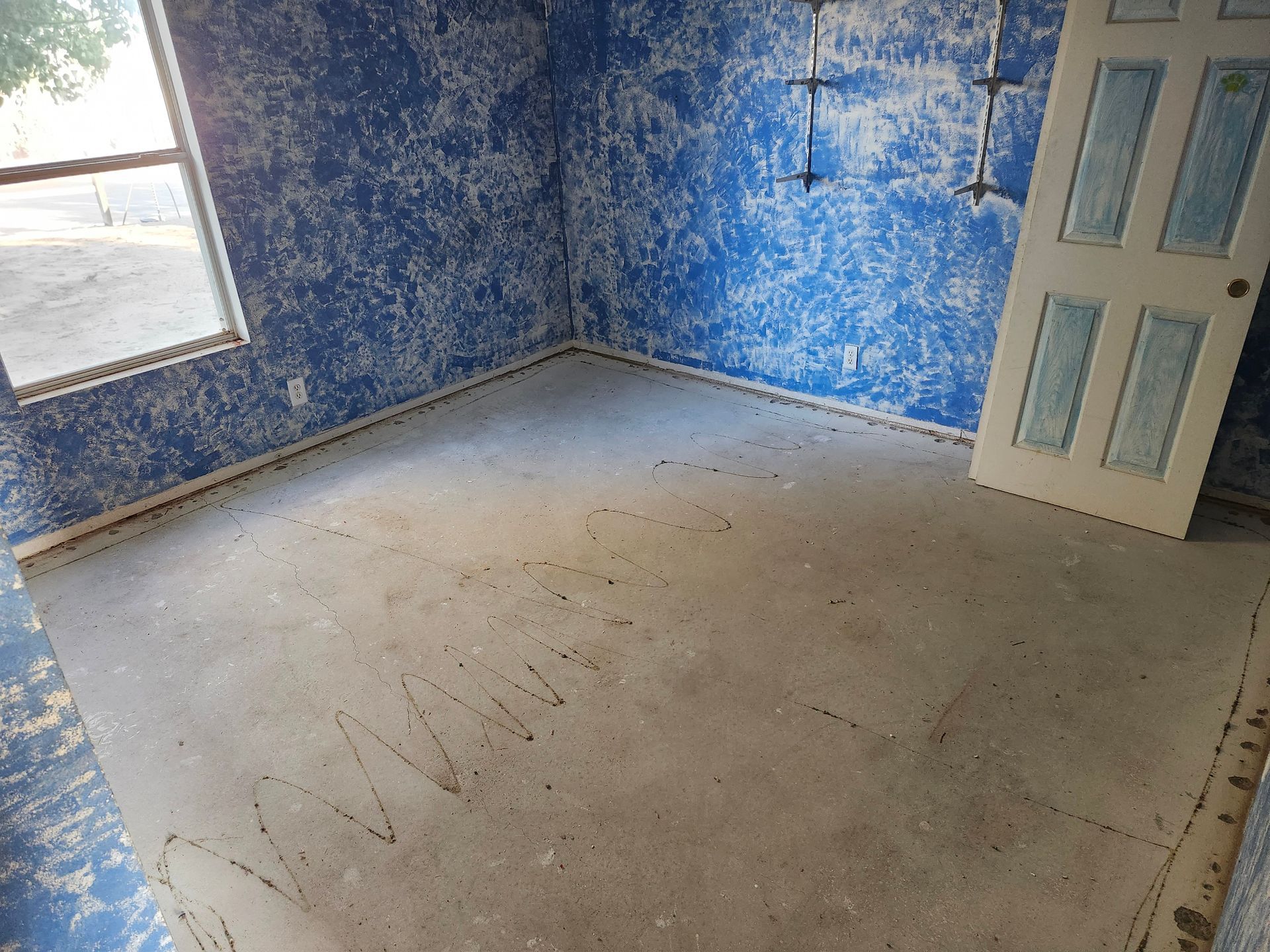 An empty room with blue walls and a white door