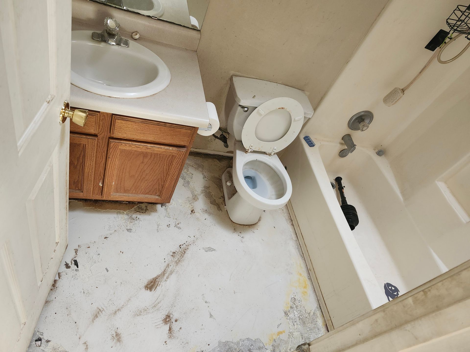 A bathroom with a toilet , sink and bathtub.