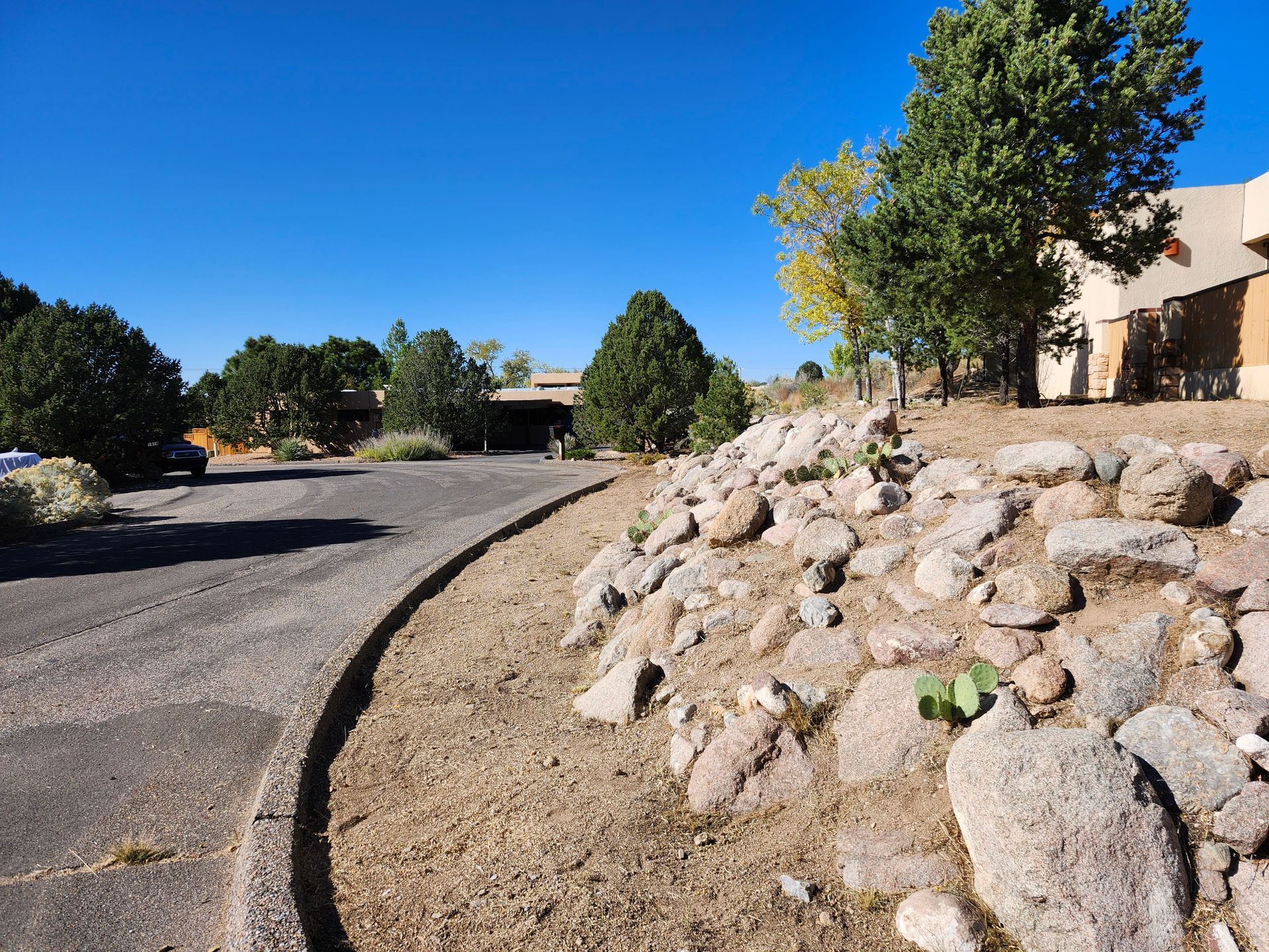 A curved road with a pile of rocks on the side of it.