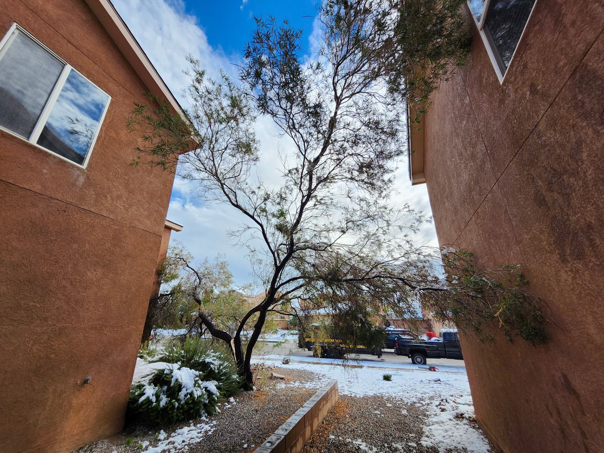 A narrow alleyway between two buildings with snow on the ground