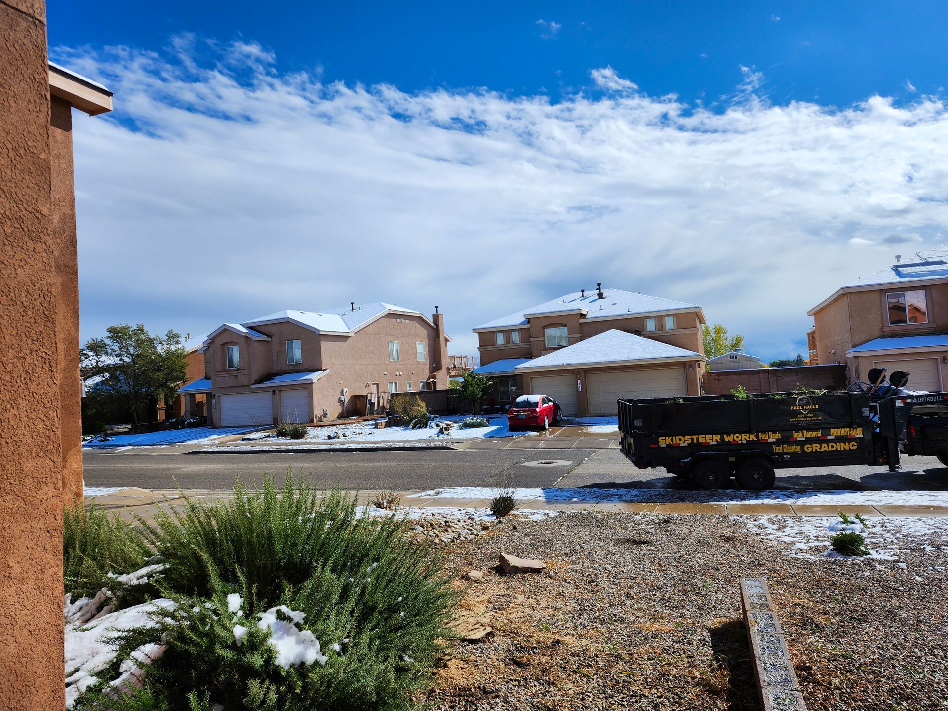 A dumpster is parked in front of a residential neighborhood.