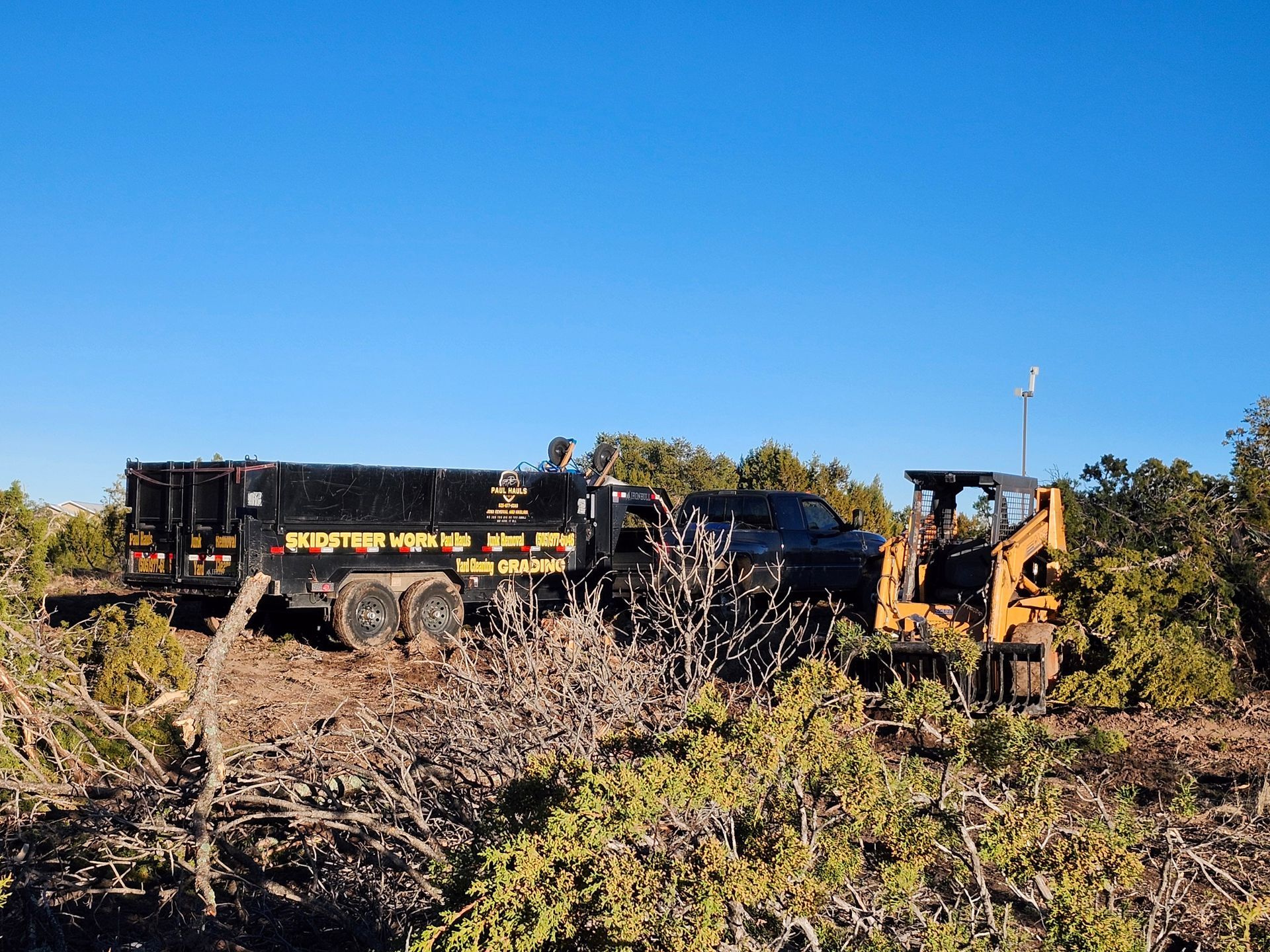 A truck and a bulldozer are parked in a field.