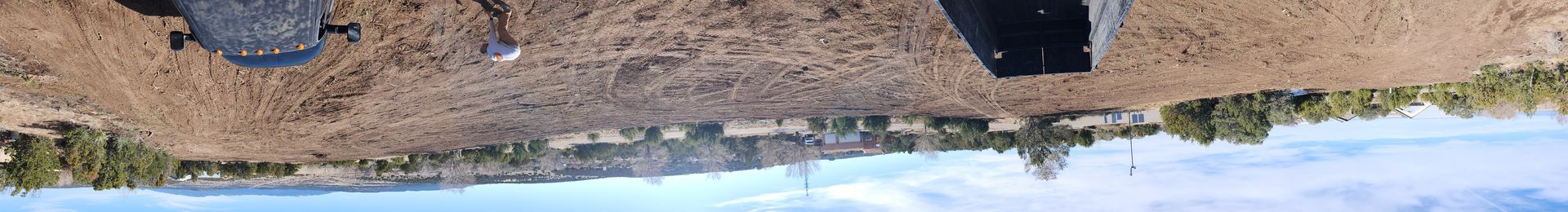 A group of people standing on top of a dirt hill.