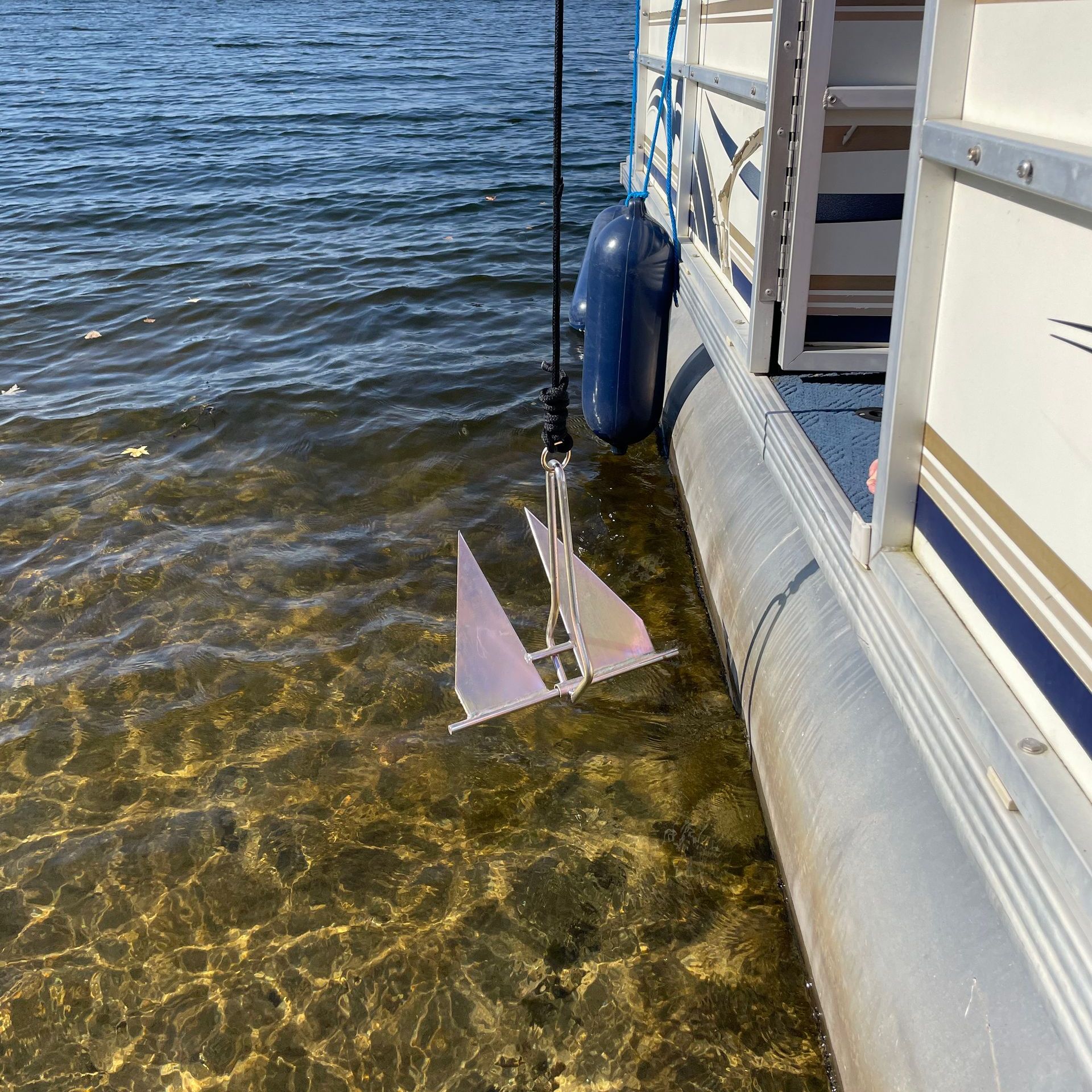 An anchor is attached to the side of a boat in the water