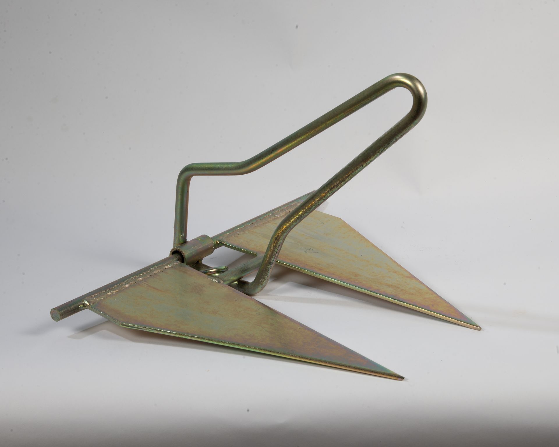 A metal anchor with a handle on a white surface