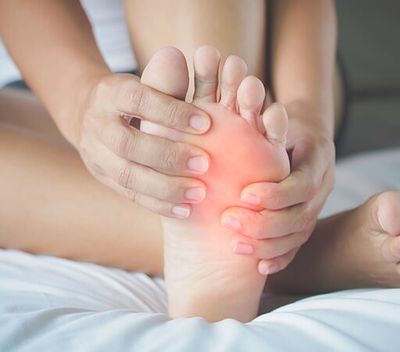 Woman feeling pain in her foot — Podiatrist in Wichita, KS