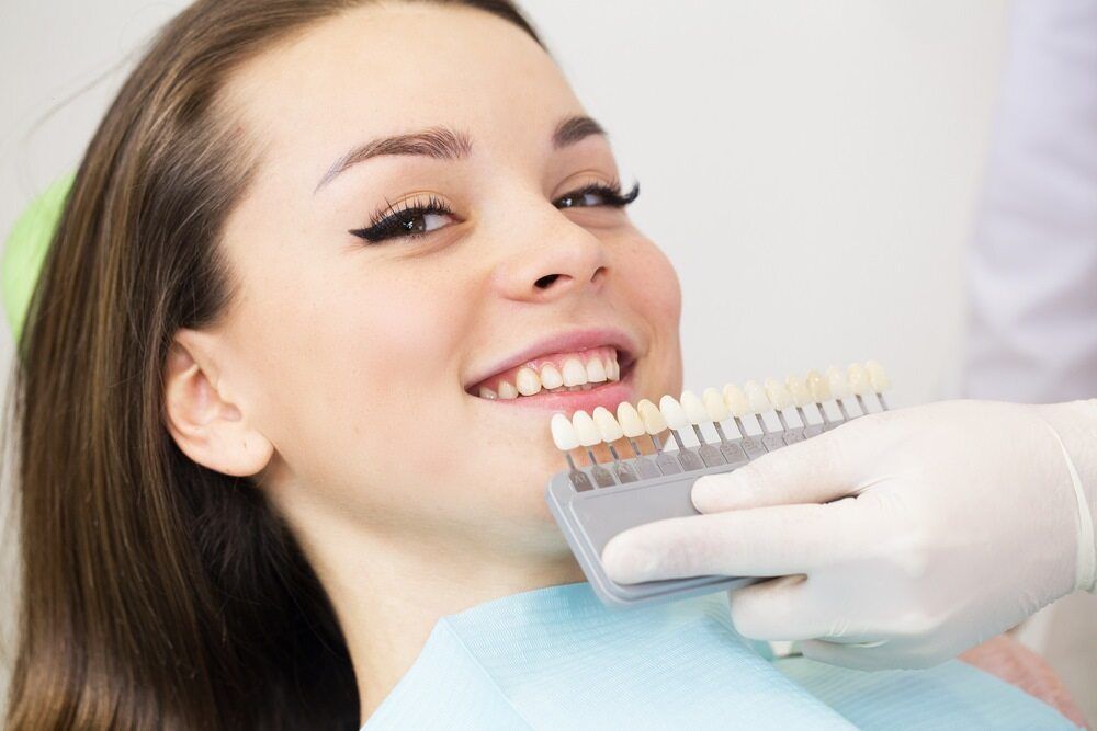A Woman is Sitting in a Dental Chair While a Dentist Examines Her Teeth — Cairns Precision Dental Group In Woree, QLD