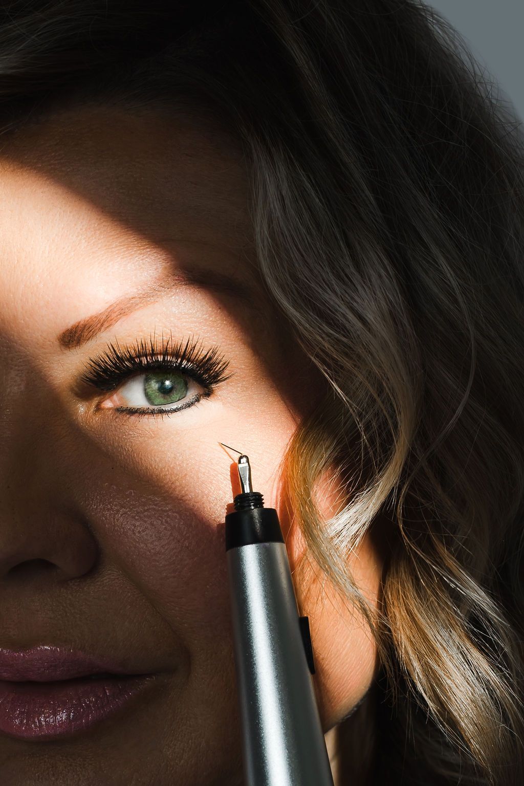 A woman is getting a laser treatment on her face.