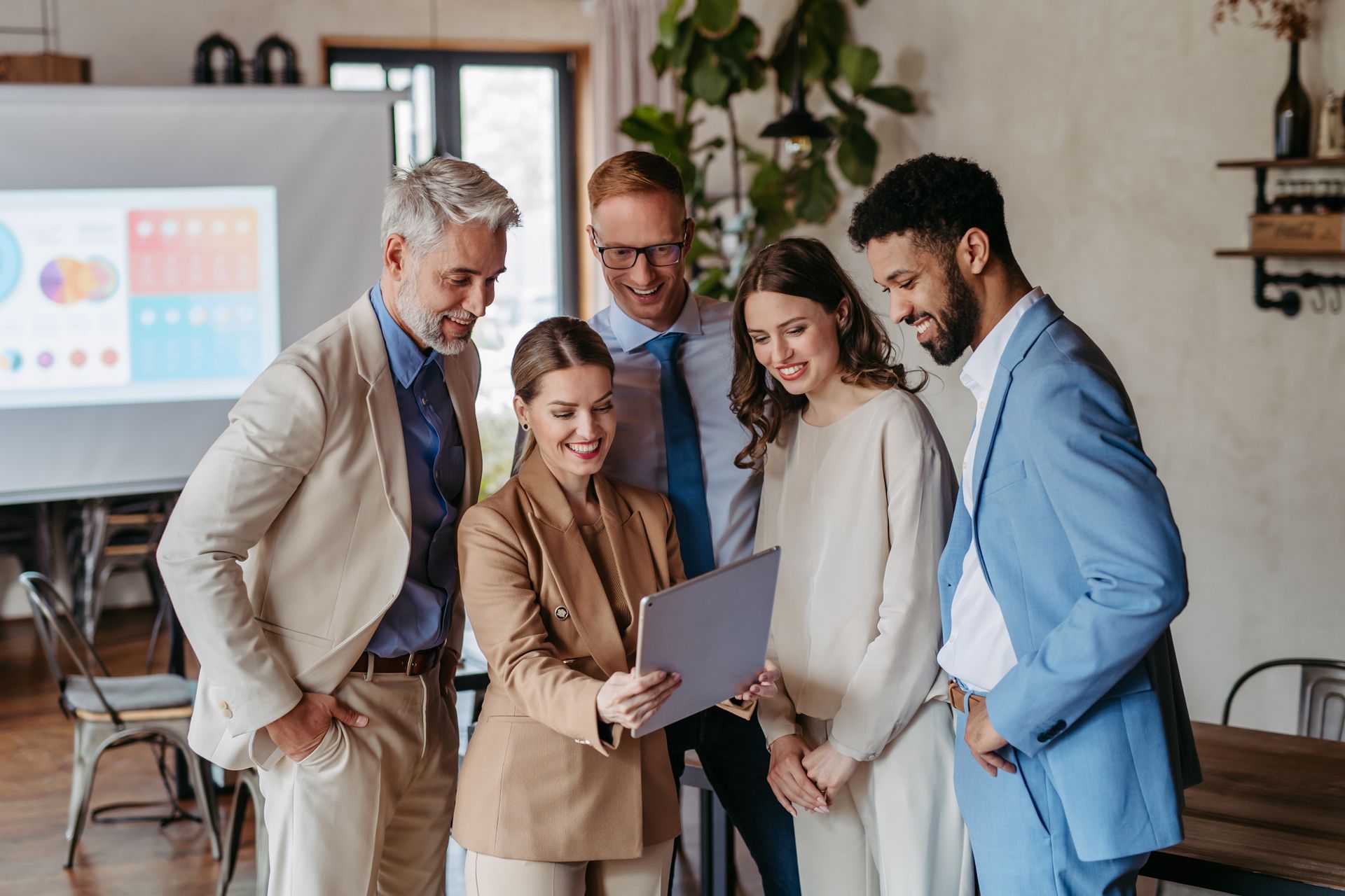 A group of business people are looking at a laptop computer.