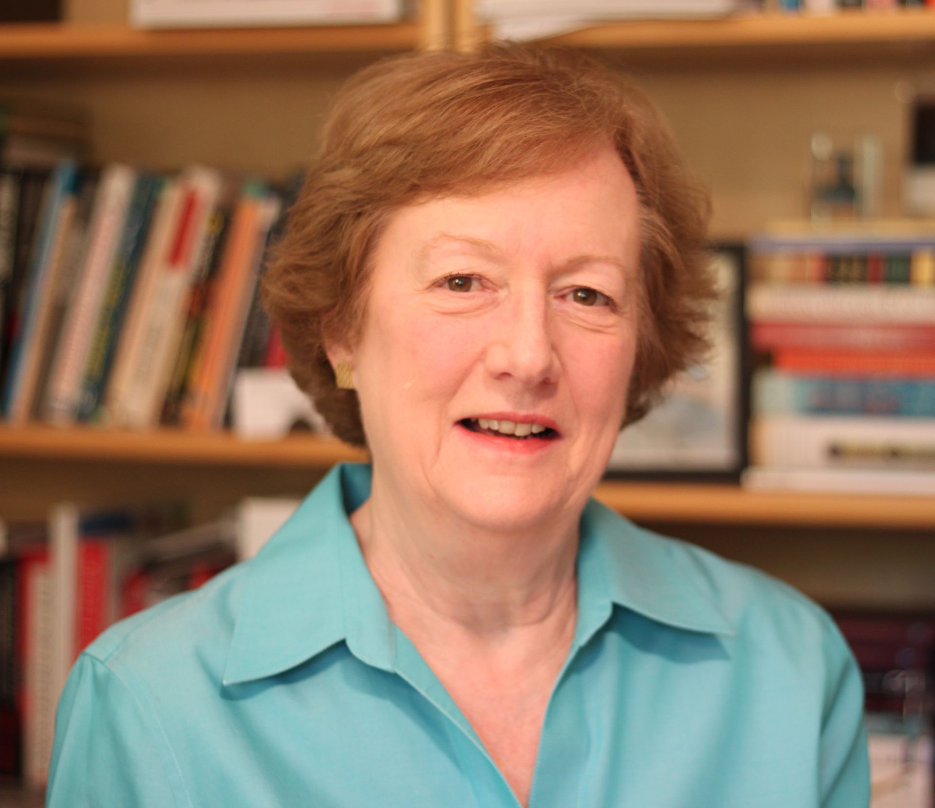 Photo of author Catherine Mathis sitting in front of bookshelves.