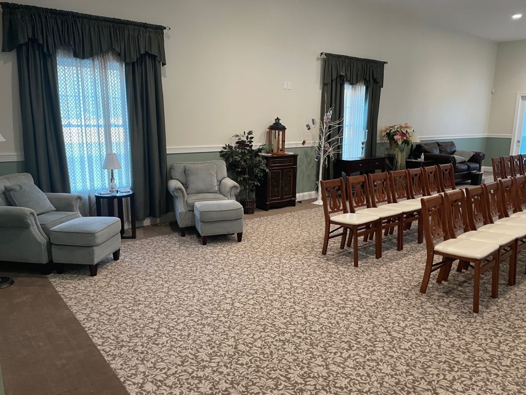 A large room with a lot of chairs and ottomans in it.