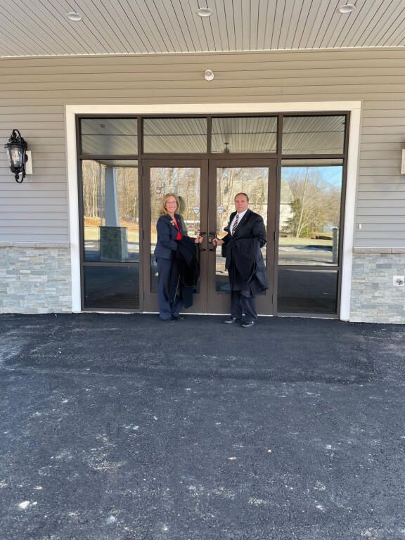 A man and a woman are standing in front of a building.