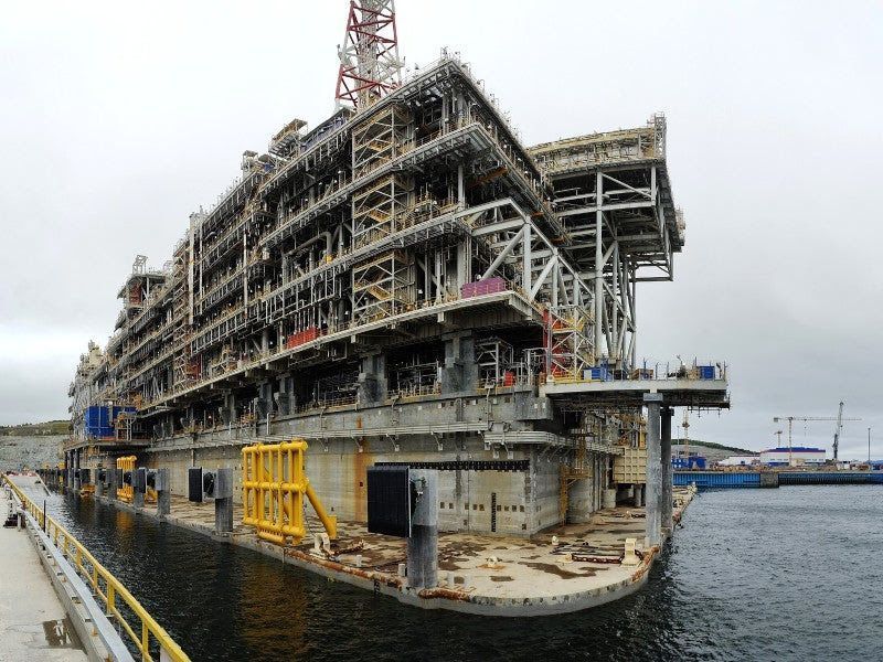 Large industrial structure on a dock, likely an oil platform under construction with multiple levels and metal framework.