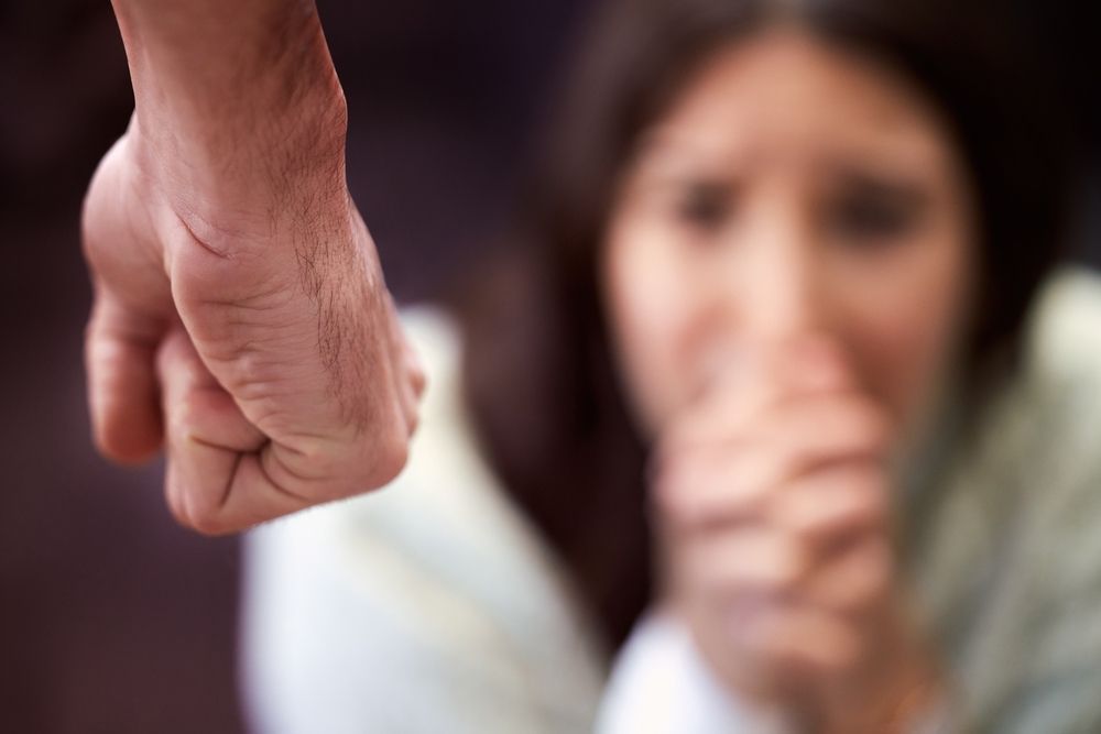 A man is holding a woman 's hand in front of her face.