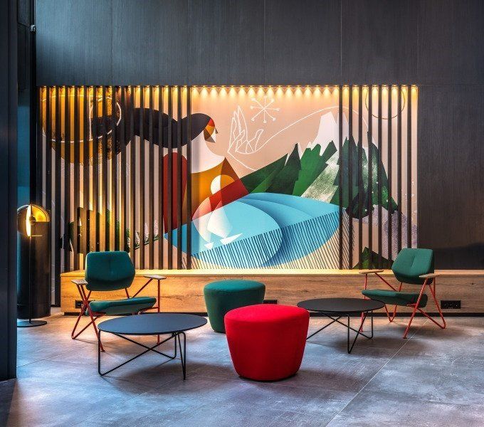 Ein Raum mit Stühlen und Tischen und einem Gemälde an der Wand