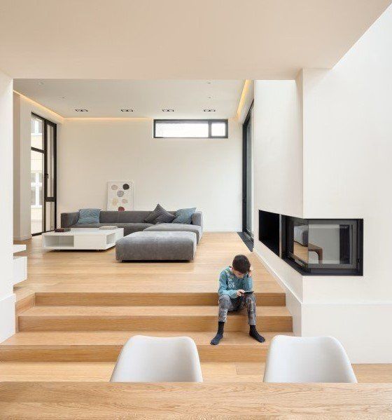 Ein Junge sitzt auf der Treppe in einem Wohnzimmer und schaut auf sein Telefon