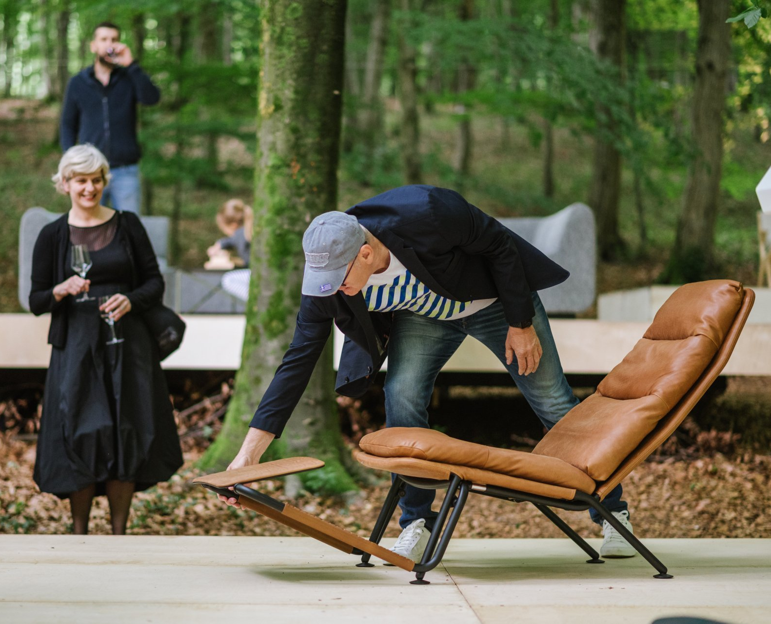 Ein Mann kniet neben einem braunen Stuhl