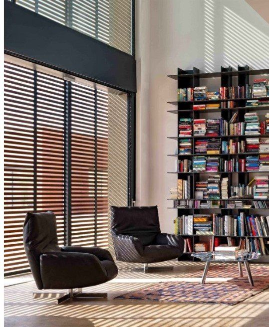 Ein Wohnzimmer mit zwei Stühlen und einem Bücherregal voller Bücher