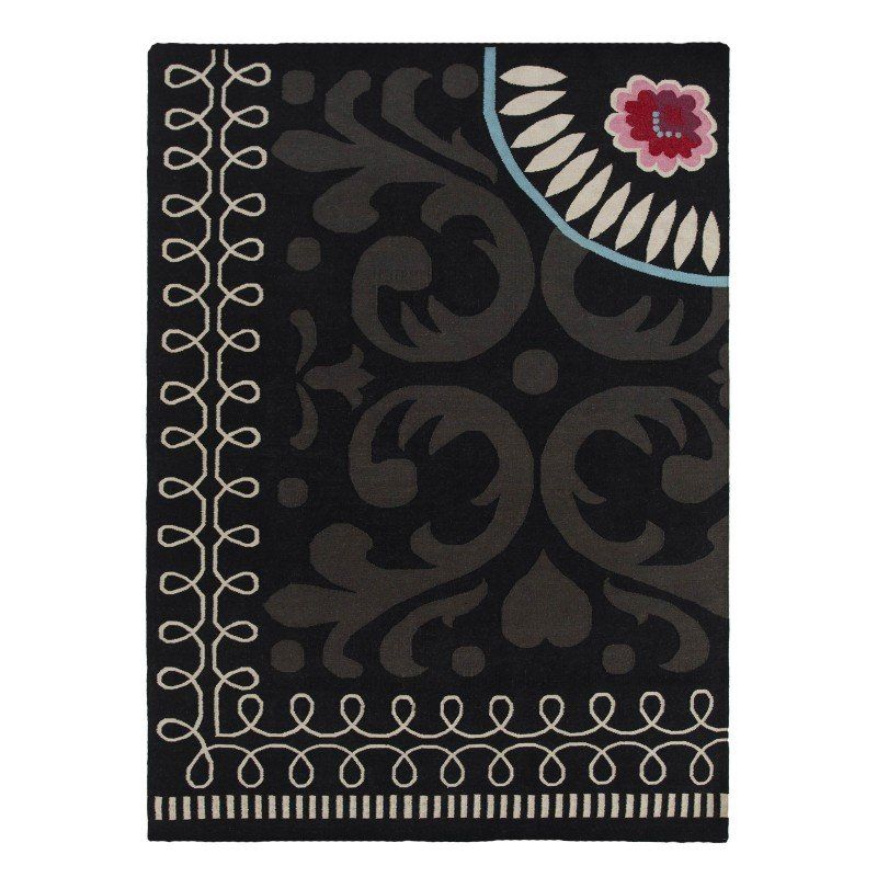 Ein schwarzer Teppich mit weißen Wirbeln und einer Blume darauf