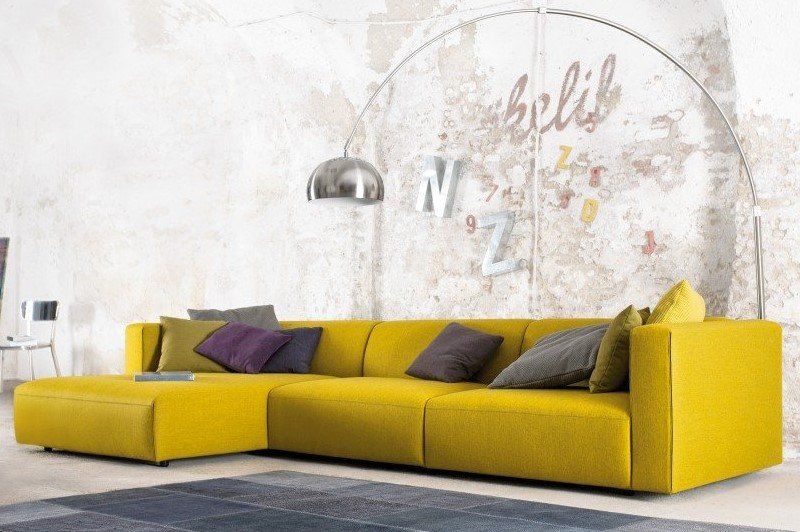 Ein gelbes Sofa vor einer Wand mit der Aufschrift „Belib“