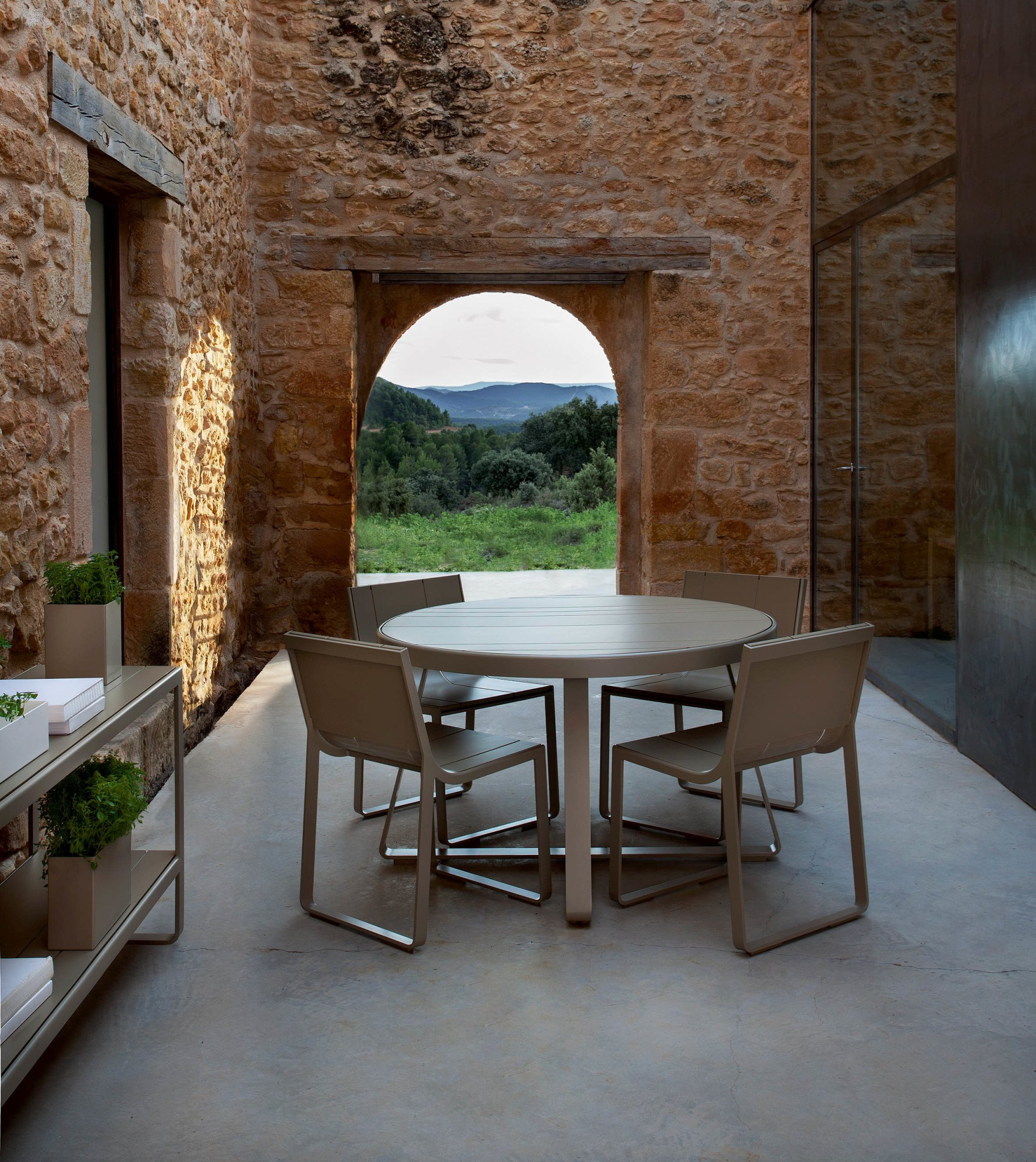 Ein Tisch und Stühle vor einer Steinmauer