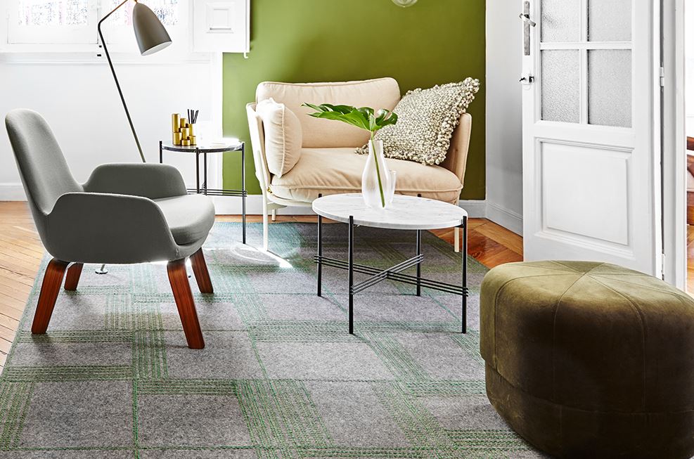 Ein Wohnzimmer mit Couch, Sessel, Tisch und Ottomane